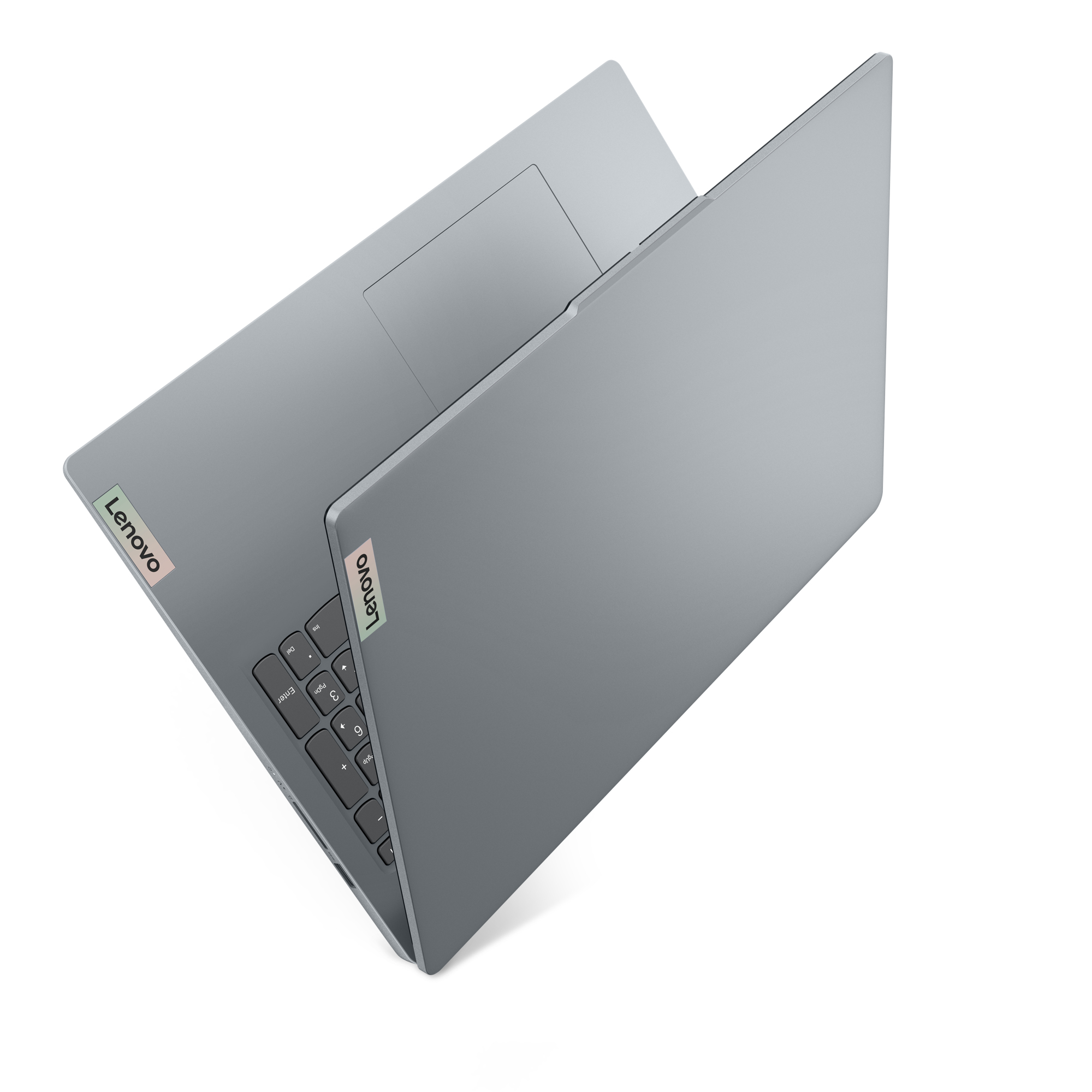 Szary laptop Lenovo, częściowo otwarty. Widoczne naklejki Lenovo. Widok pod kątem, białe tło.