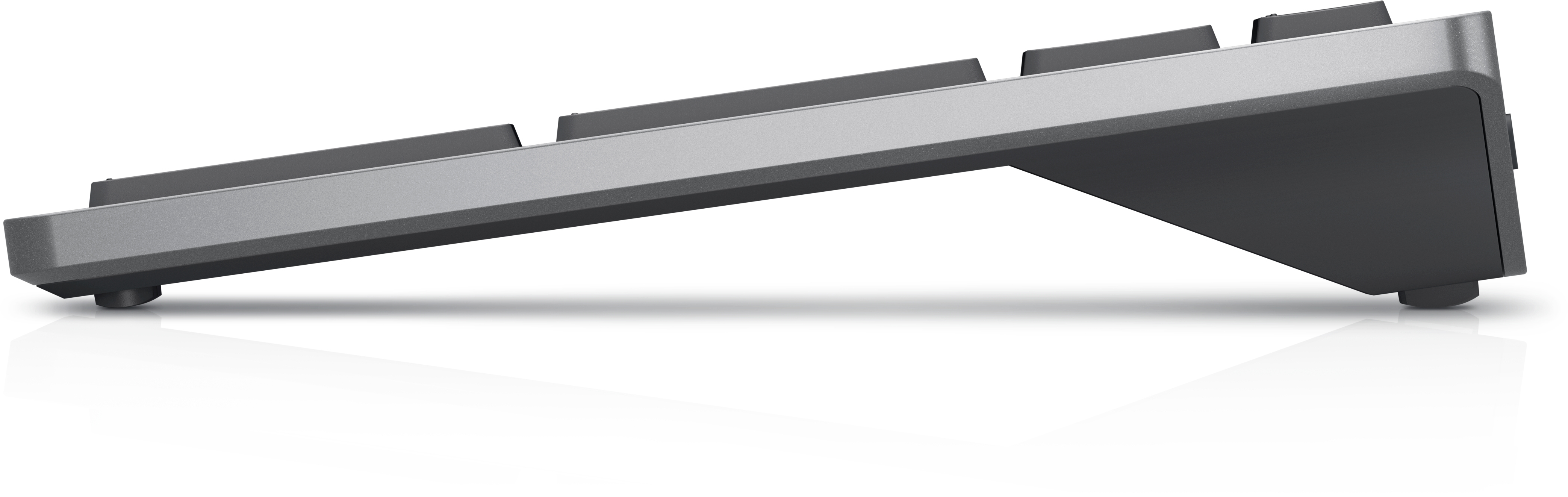 Srebrna klawiatura widziana z boku, pokazująca jej lekko pochyloną konstrukcję.