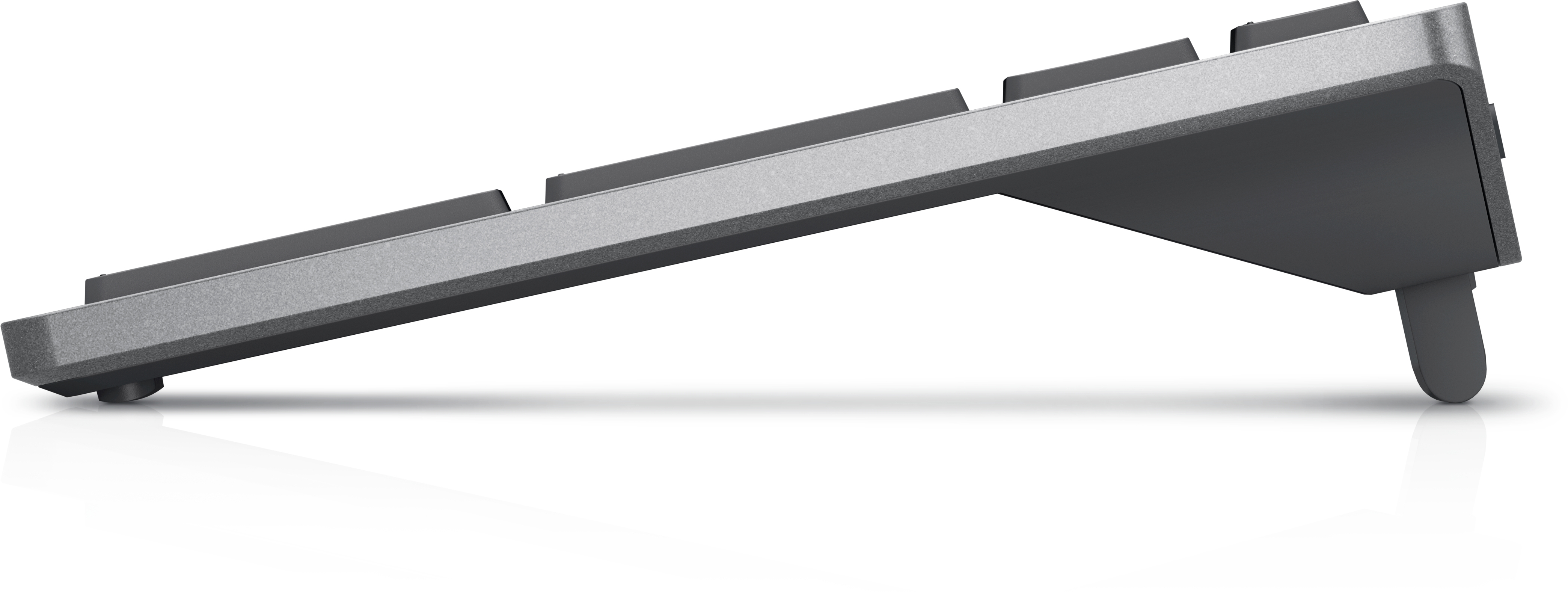 Widok z boku szarej klawiatury bezprzewodowej, skierowanej w górę, z białą, odblaskową powierzchnią poniżej.