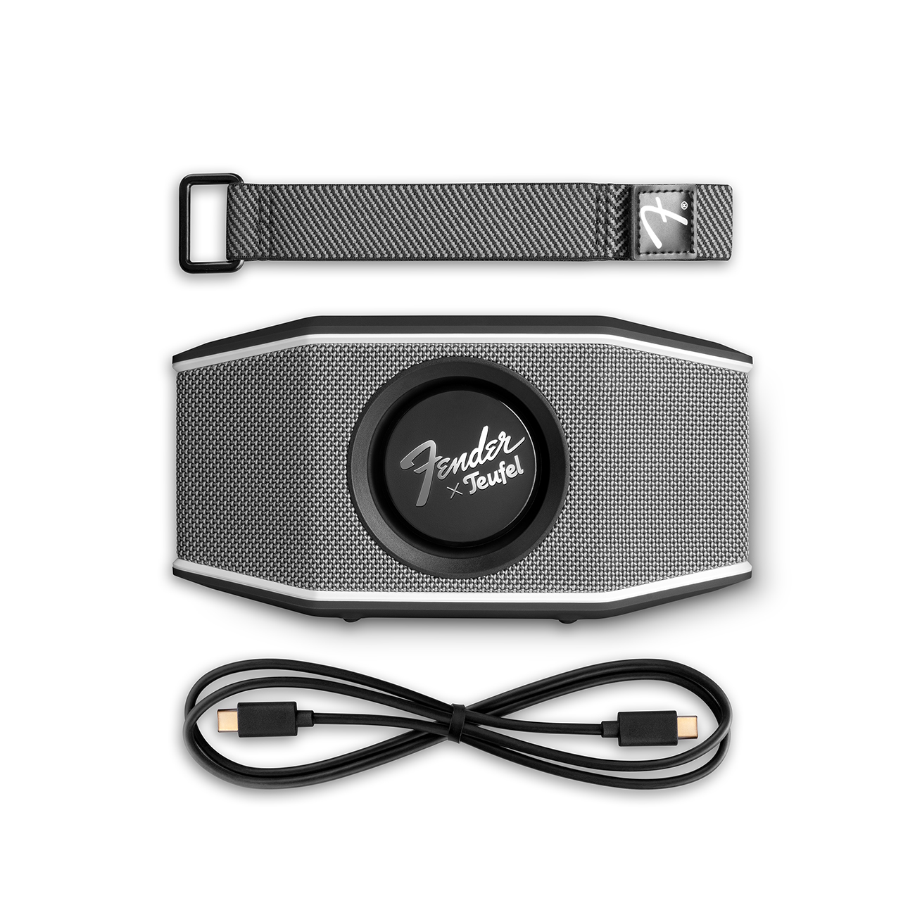 Zwarte en grijze Fender x Teufel-luidspreker met een riem en een USB-C-kabel op een witte achtergrond.