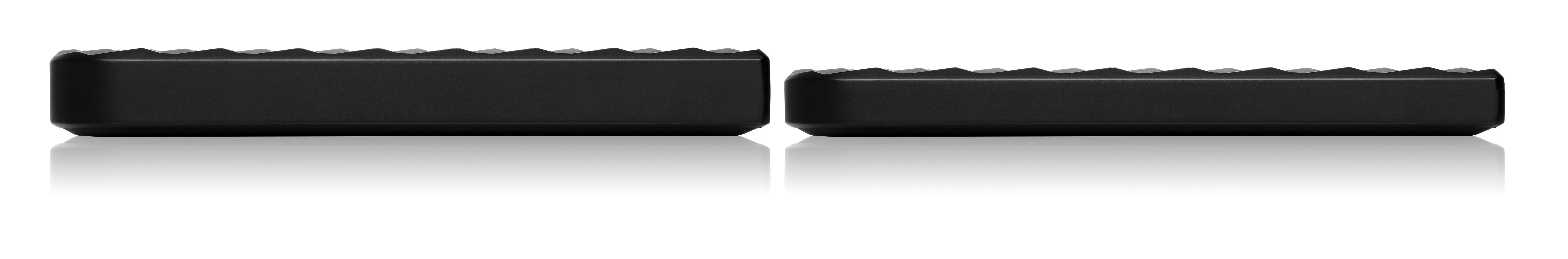 Dwa czarne prostokątne urządzenia umieszczone obok siebie na białej, odbijającej światło powierzchni.