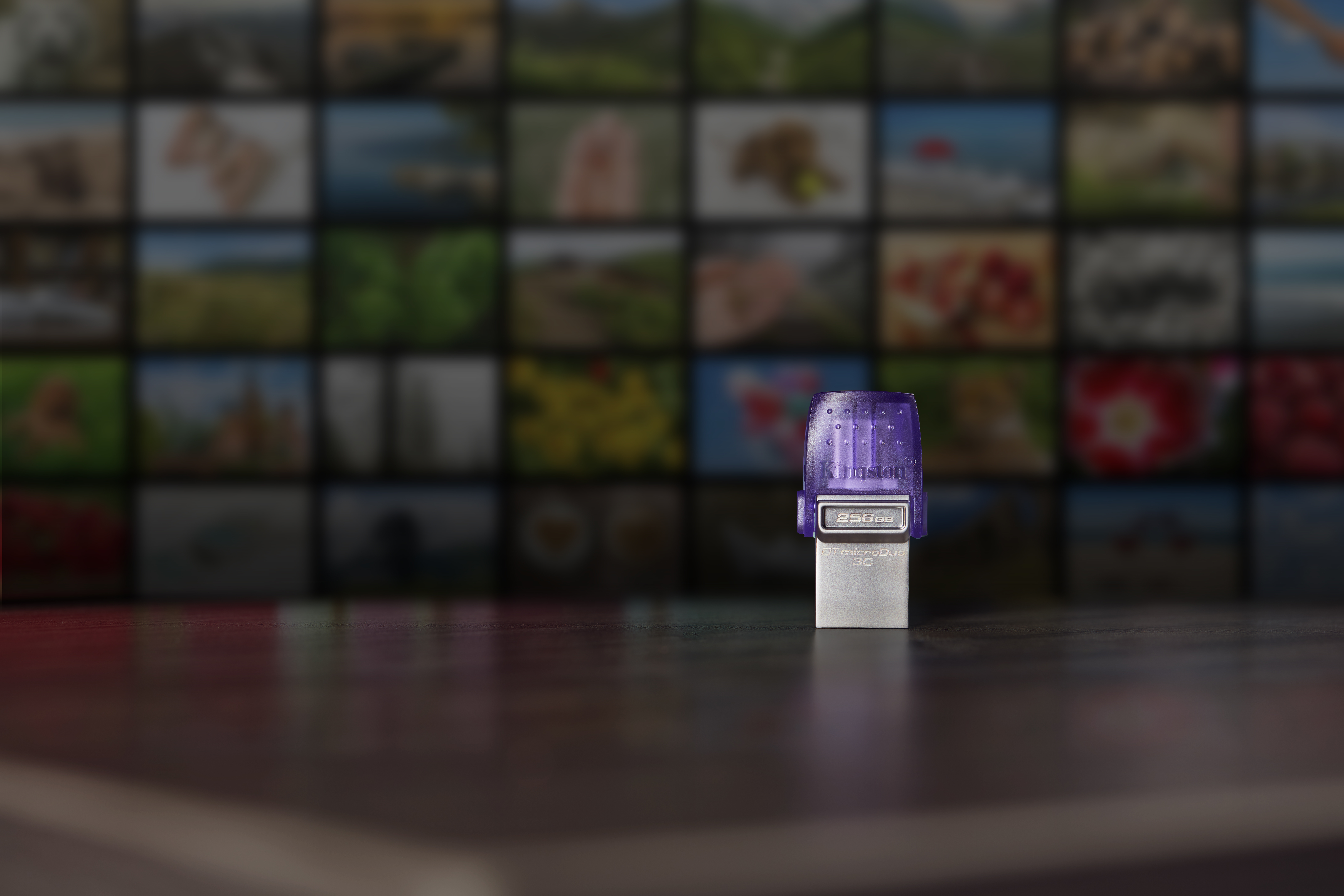 Fioletowo-biały pendrive na drewnianej powierzchni, z rozmytym tłem.