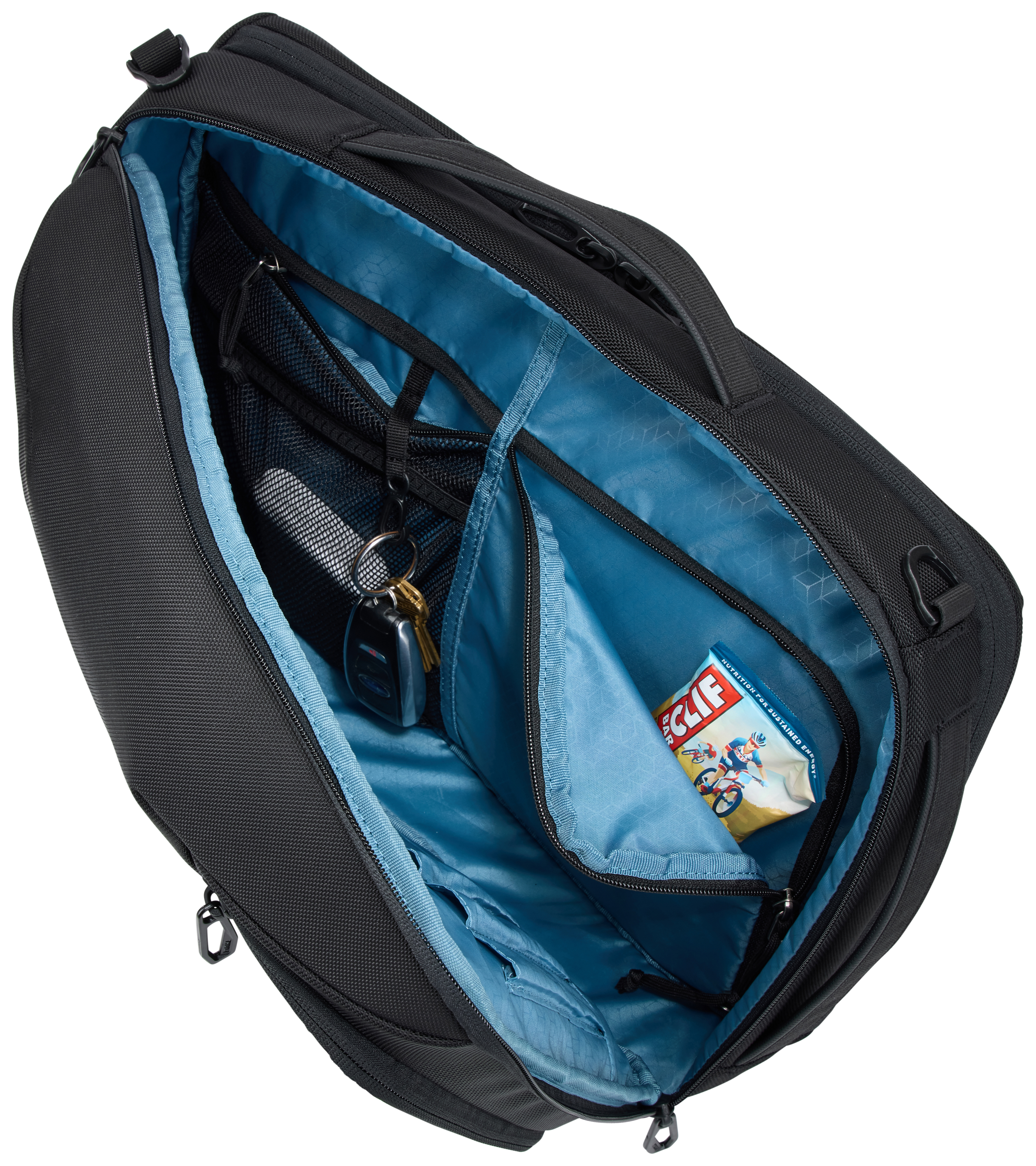 Borsa Thule nera aperta con vari scomparti. Chiavi e uno snack sono all'interno. La fodera blu è visibile.