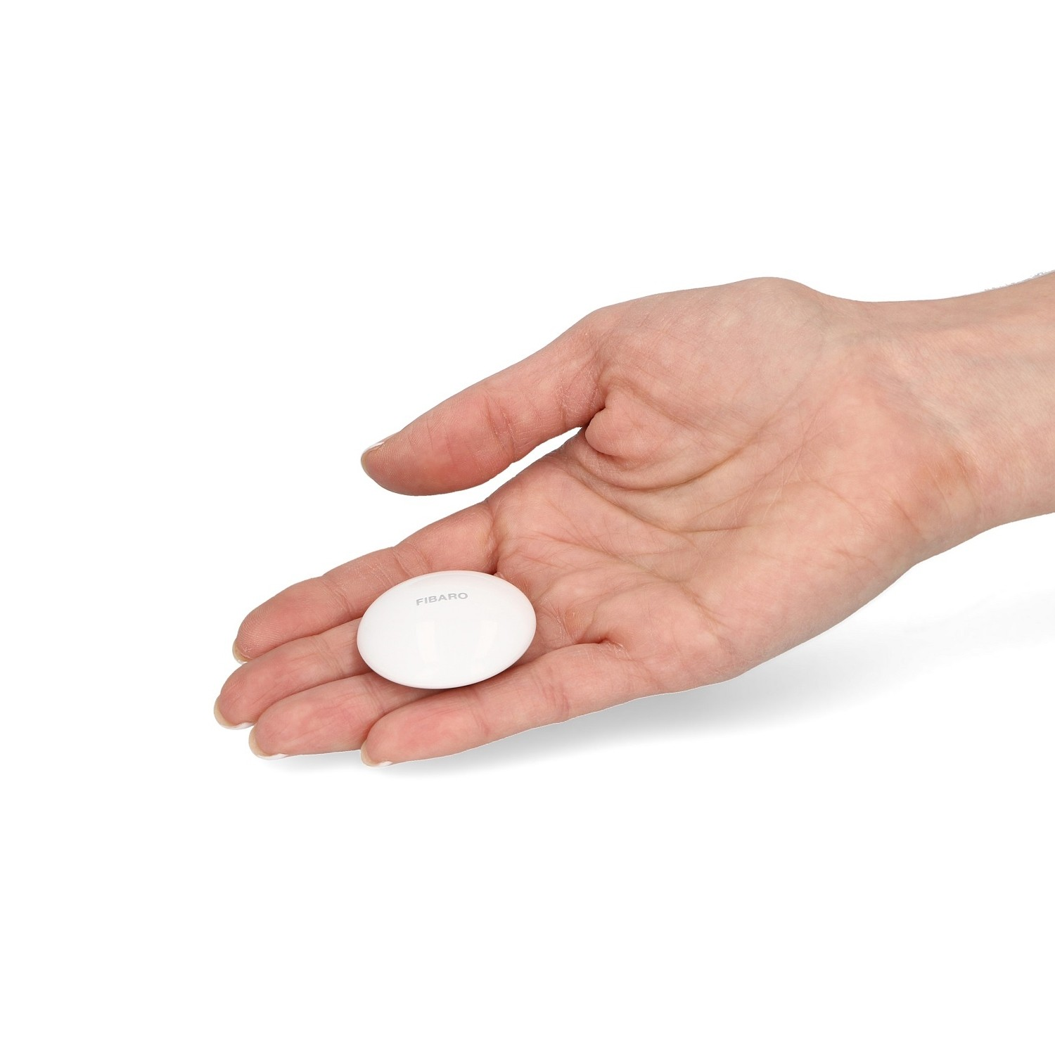 Una mano che tiene un dispositivo per la casa intelligente bianco, ovale, etichettato FIBARO. Sfondo bianco.