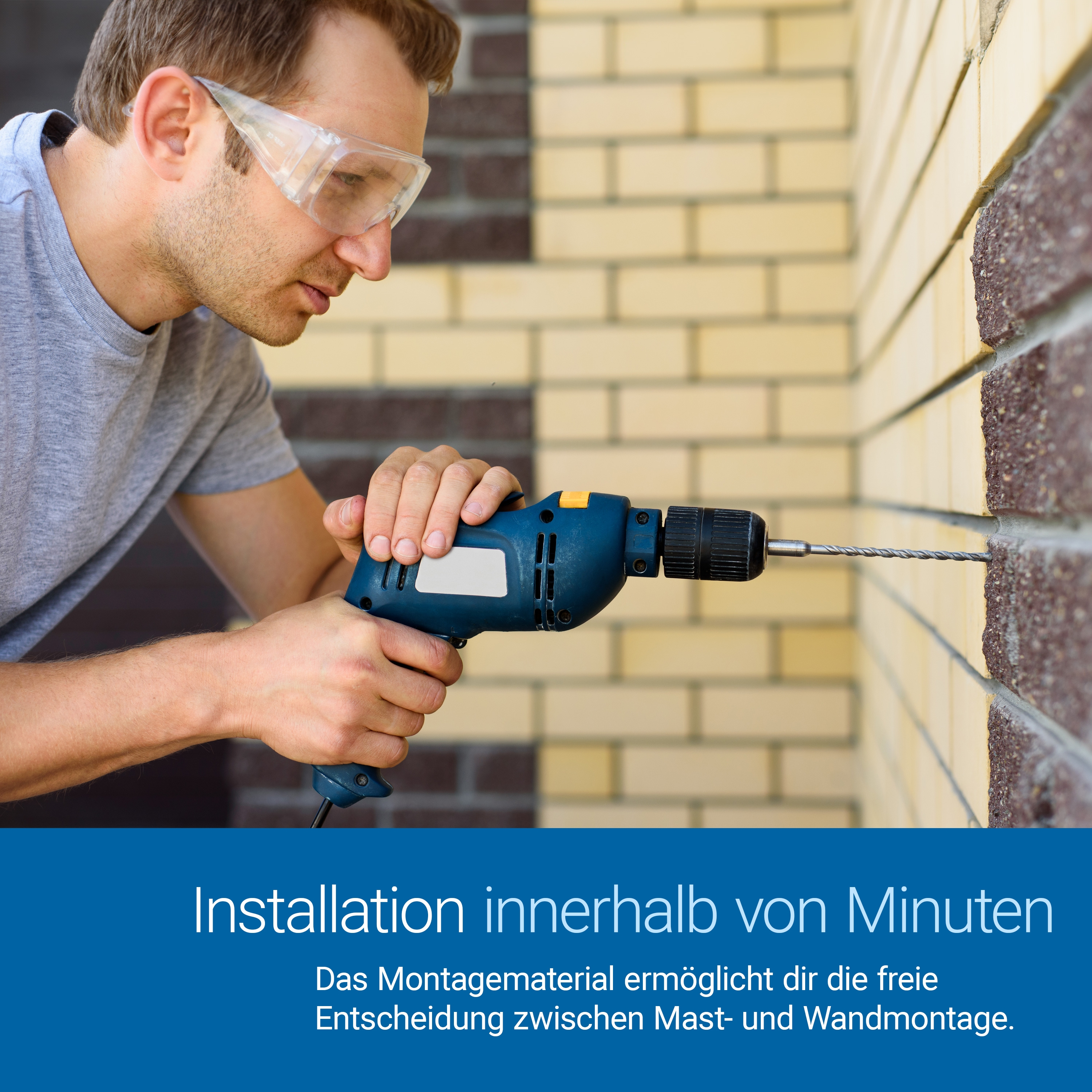 Mann bohrt in eine Wand, trägt Schutzbrille.