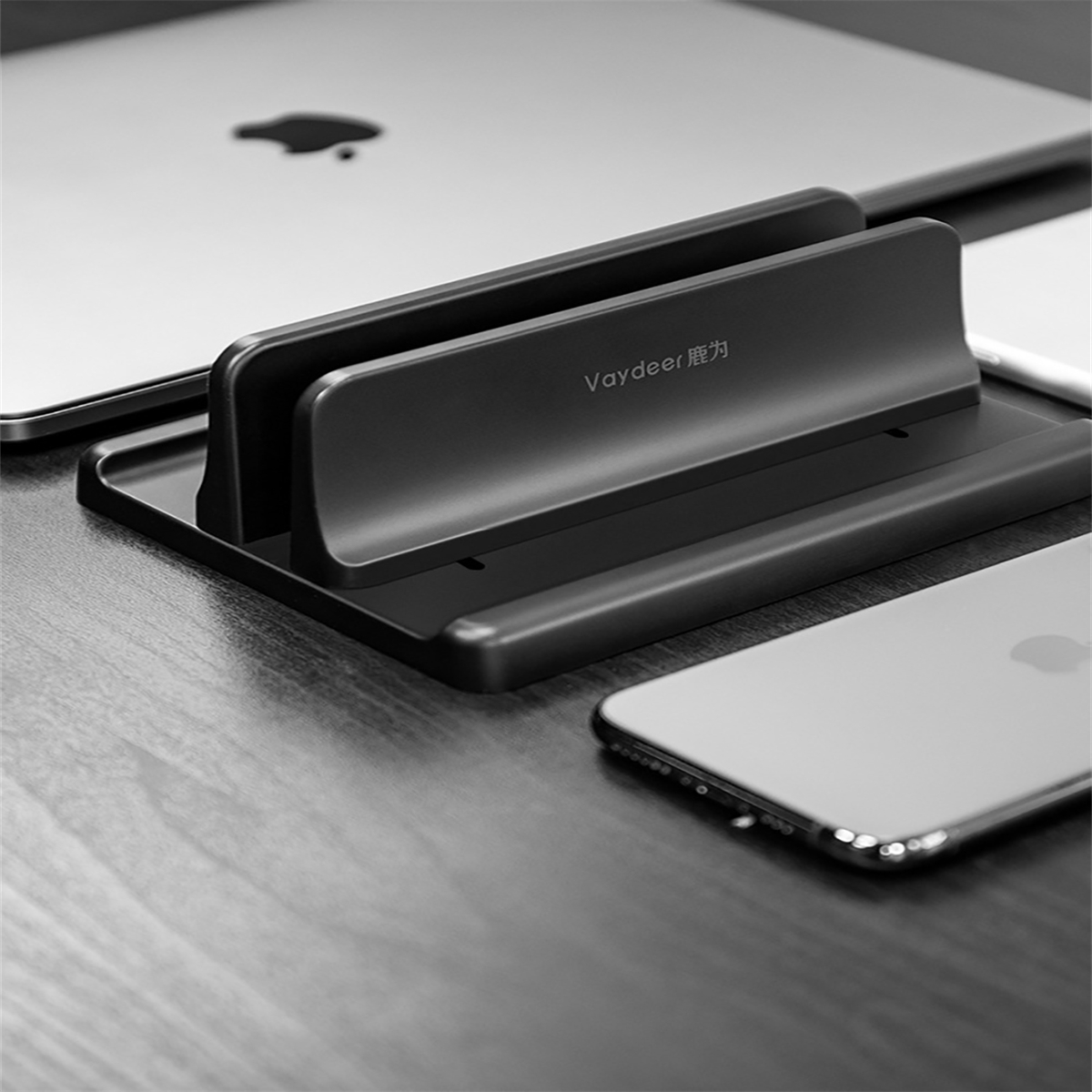 Schwarzer Laptop-Ständer mit Telefon und Laptop auf Holzoberfläche.