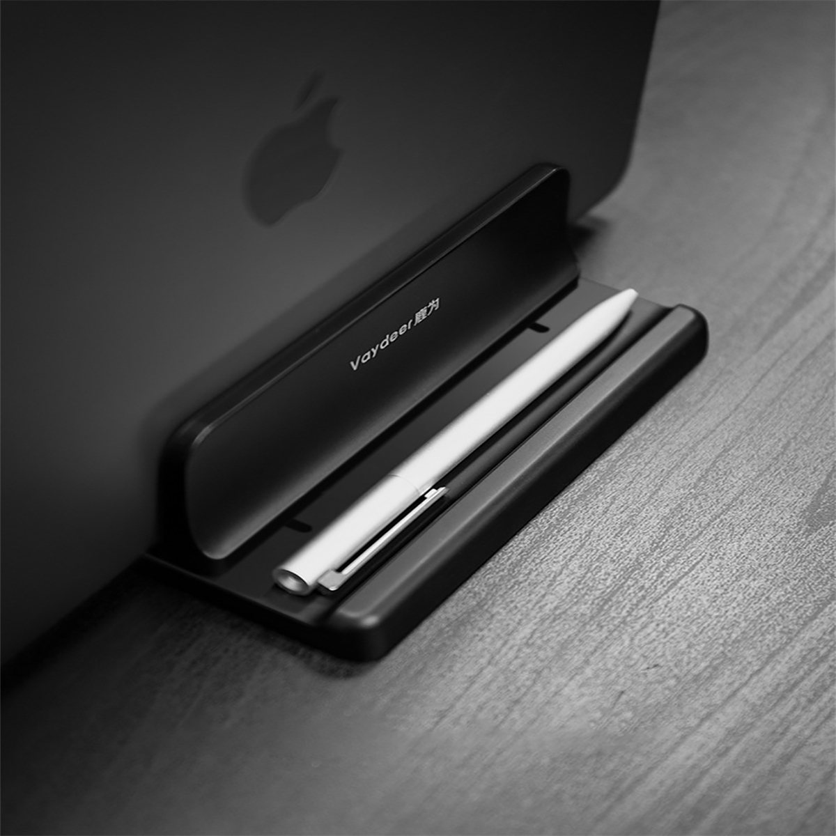 Ein schwarzer Ständer mit einem Stift darauf, der einen Laptop hält. Der Ständer und der Stift sind zentriert.