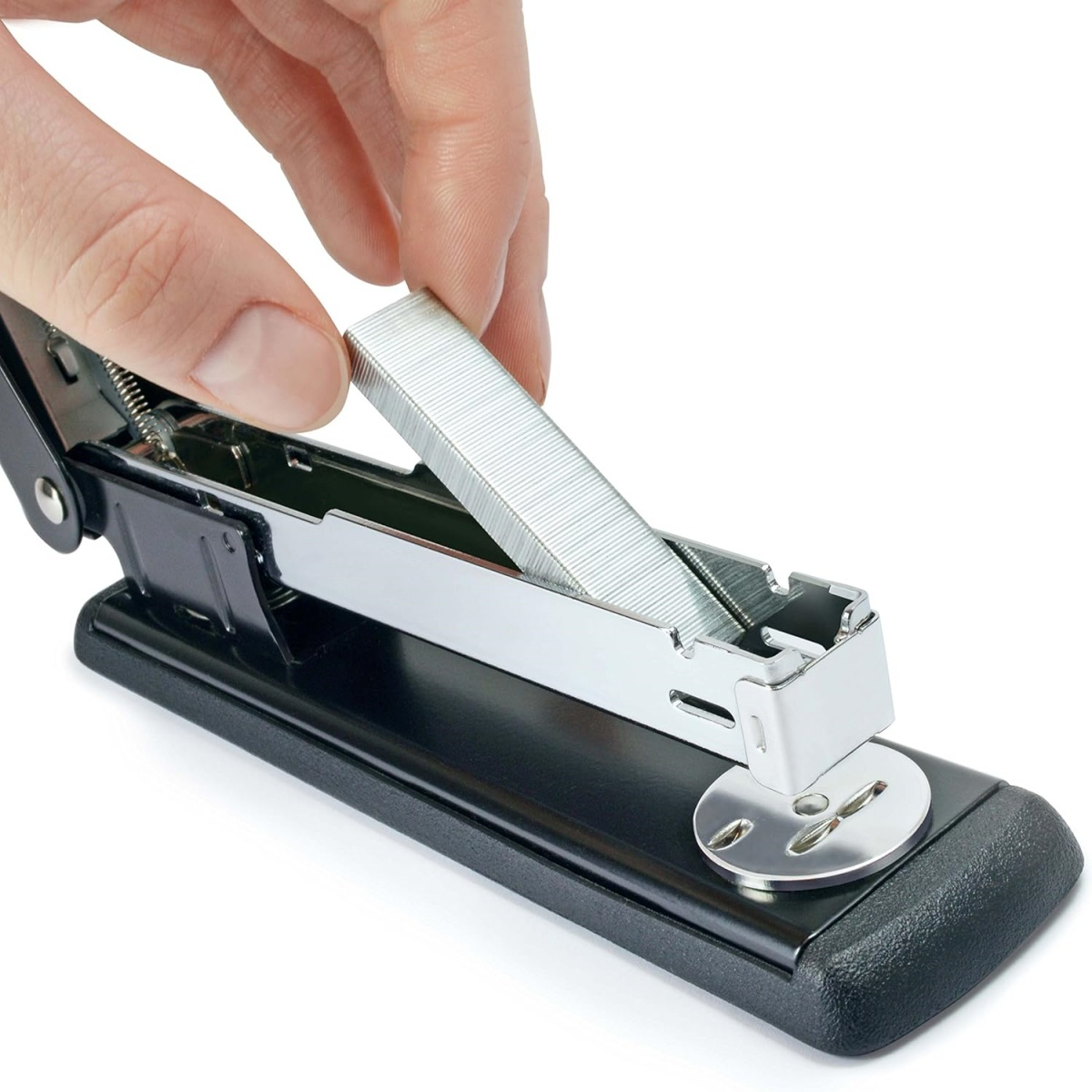 Hand lädt Heftklammern in einen schwarzen Tacker. Weißer Hintergrund, Metallteile, Nahaufnahme.