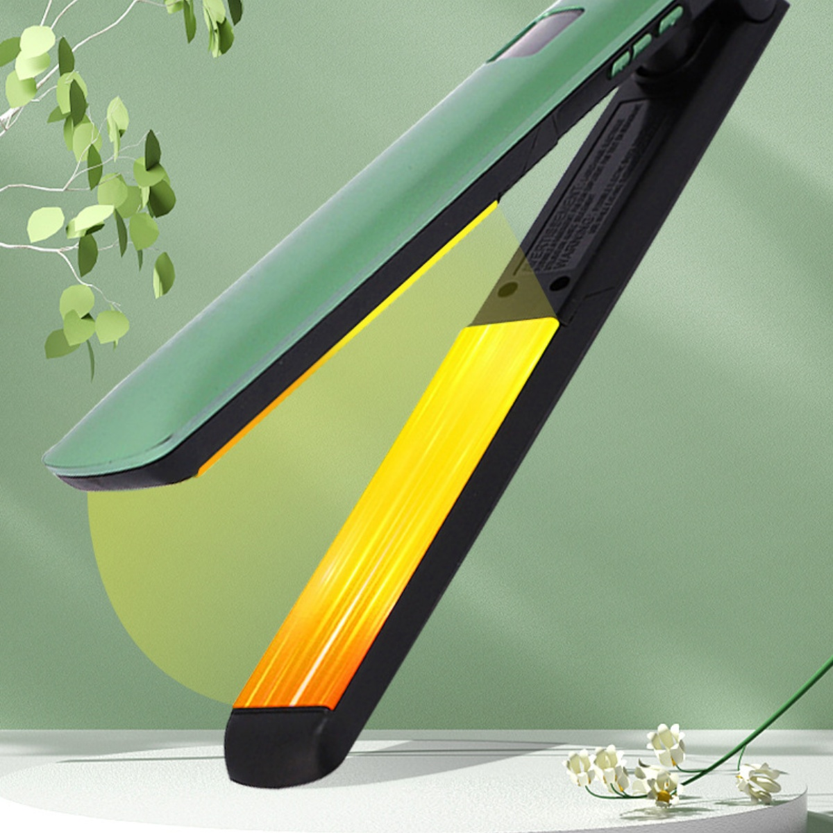 Haarglätter, grün und schwarz, mit gelben Heizplatten. Grüner Hintergrund mit Blättern.