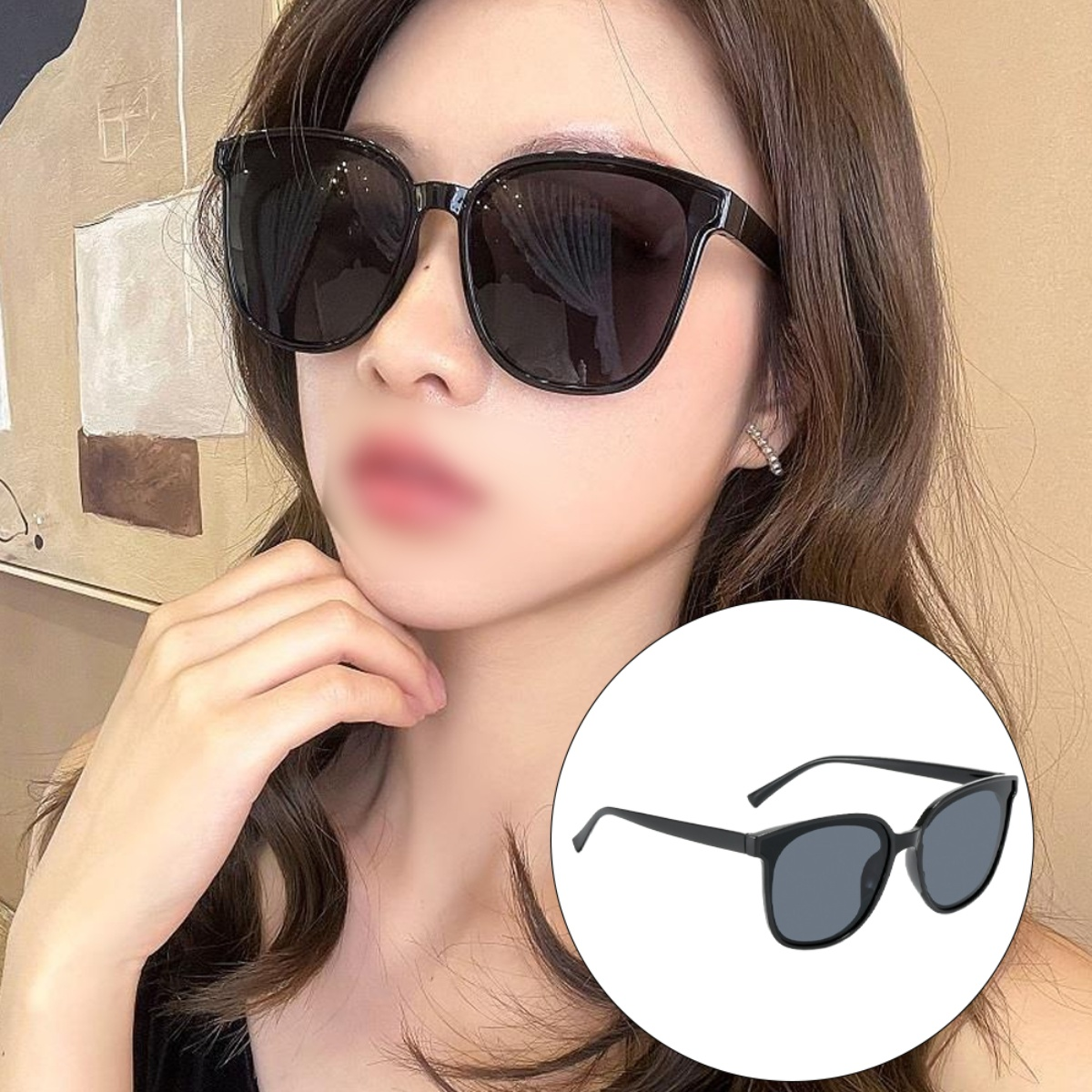 Eine Frau mit schwarzer Sonnenbrille, mit einer kleineren Sonnenbrille auf weißem Hintergrund.