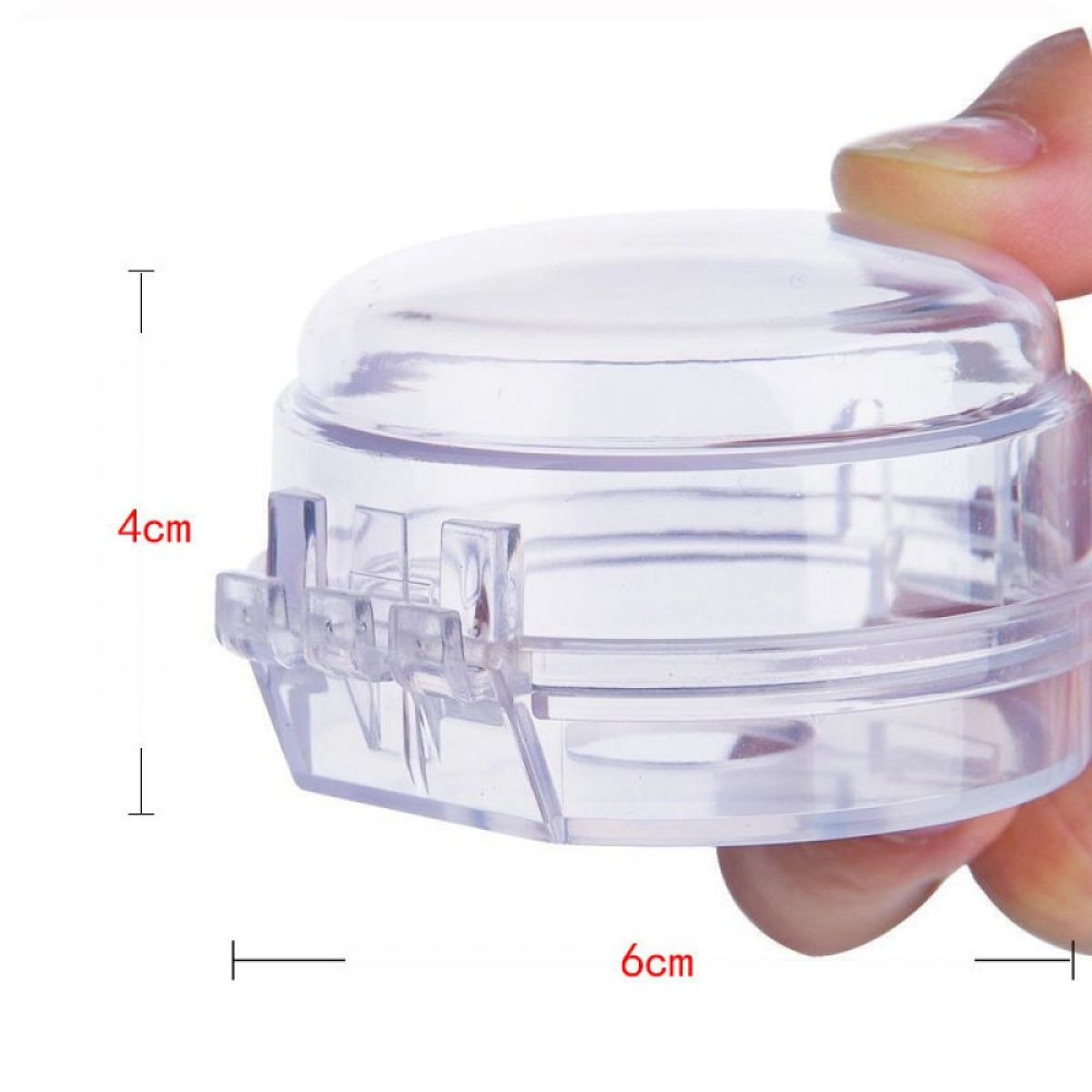 Transparente Kunststoff-Gasherd-Knopfabdeckung. Misst 4 cm hoch und 6 cm breit. Von einer Hand gehalten.