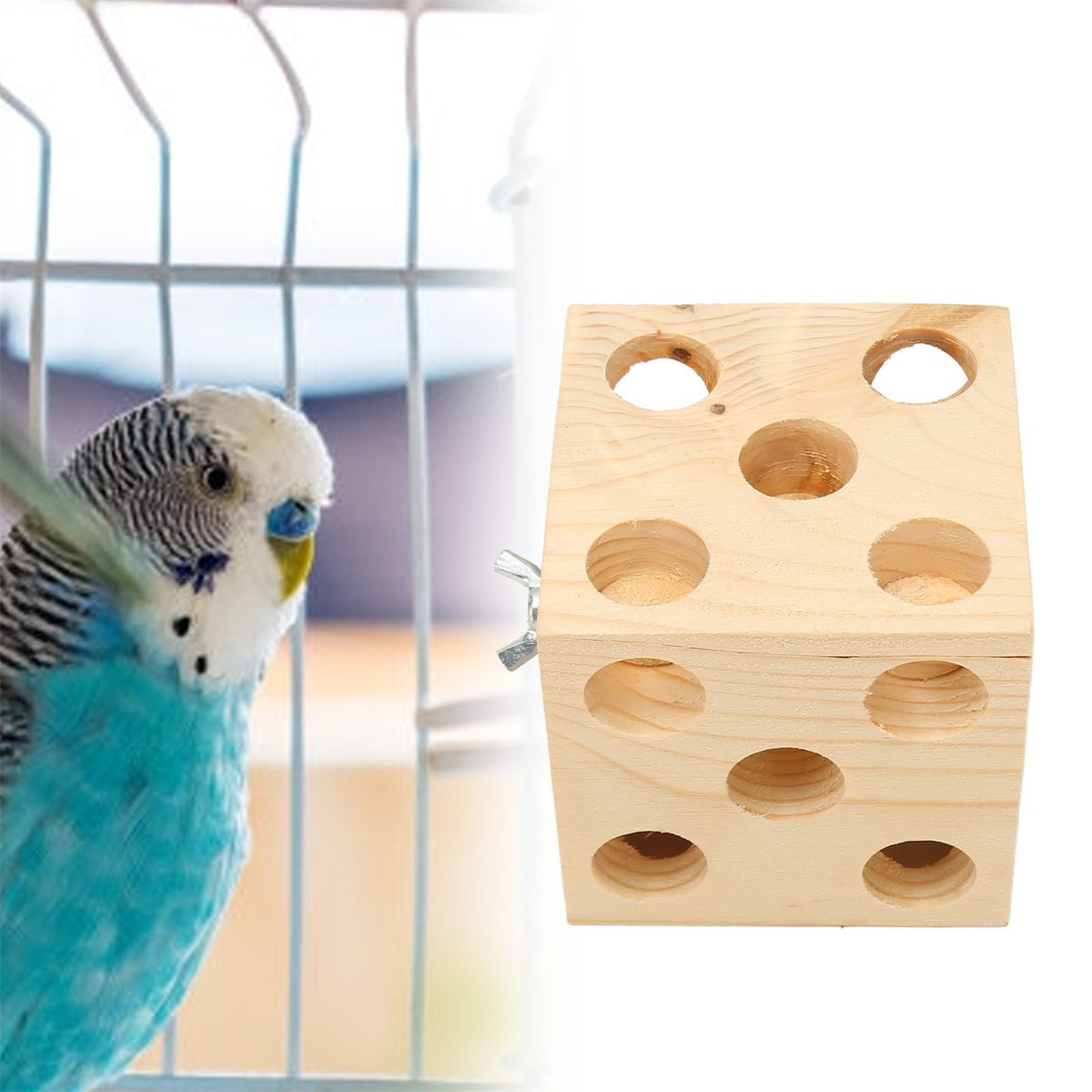 Ein blau-weißer Wellensittich neben einem Holzspielzeug mit Löchern. Ein Käfig im Hintergrund.
