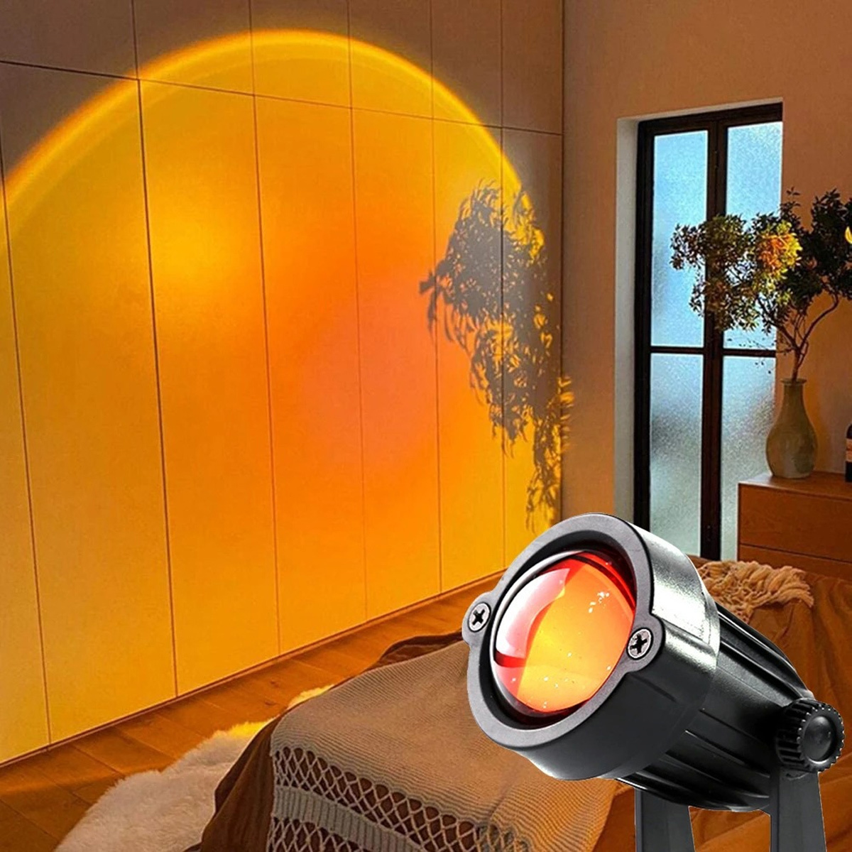 Sonnenuntergangslampe projiziert orangefarbenes Licht auf Wand und Bett. Schwarze Lampe rechts.