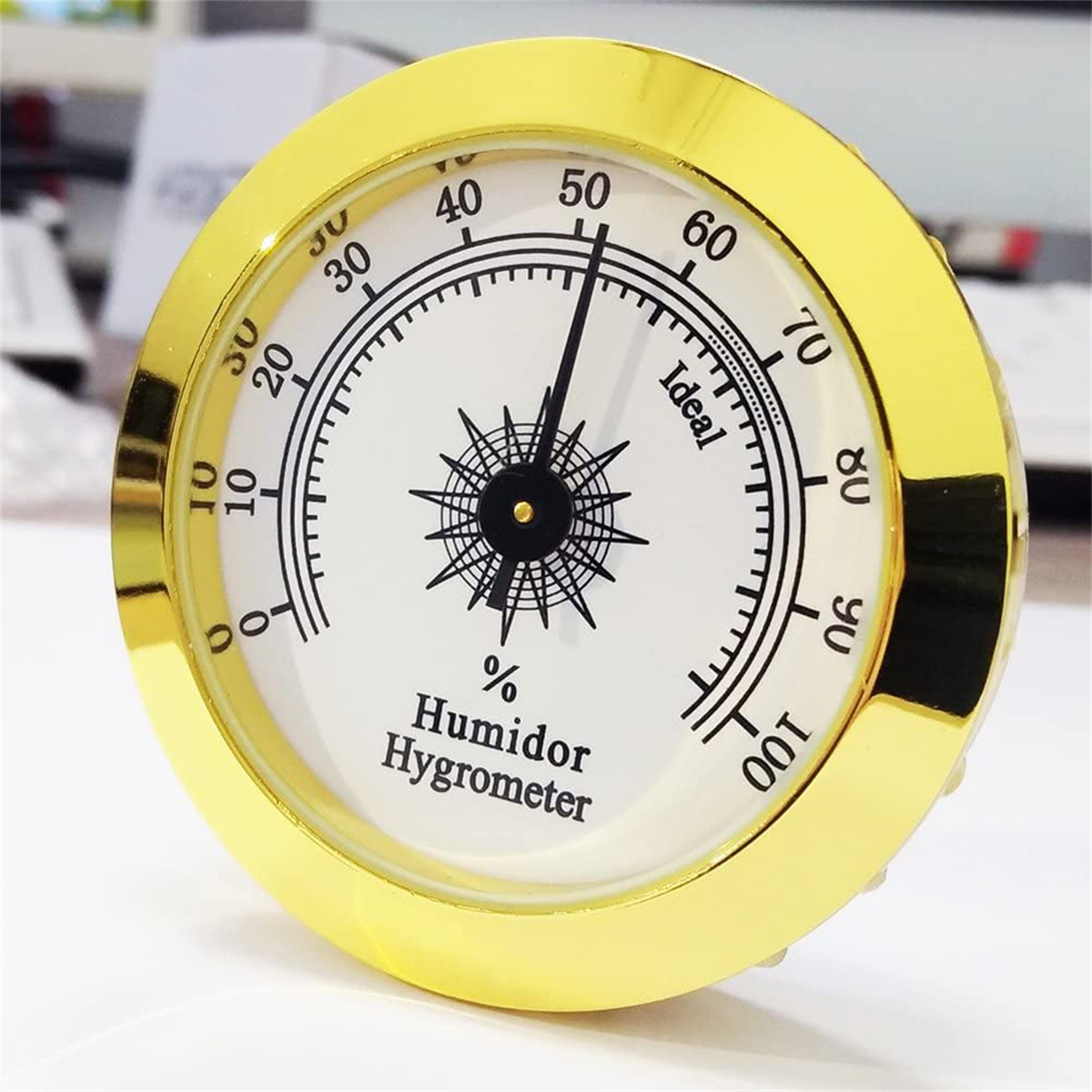 Humidor-Hygrometer mit Goldrahmen, zeigt die Luftfeuchtigkeit an.