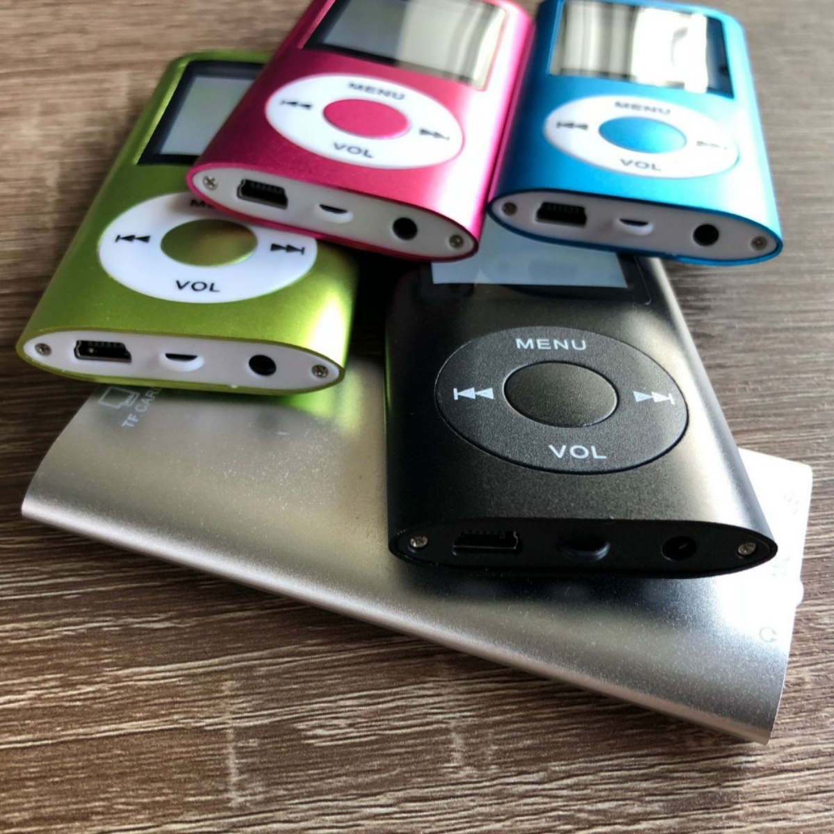 Vier farbige MP3-Player auf silberner Basis.