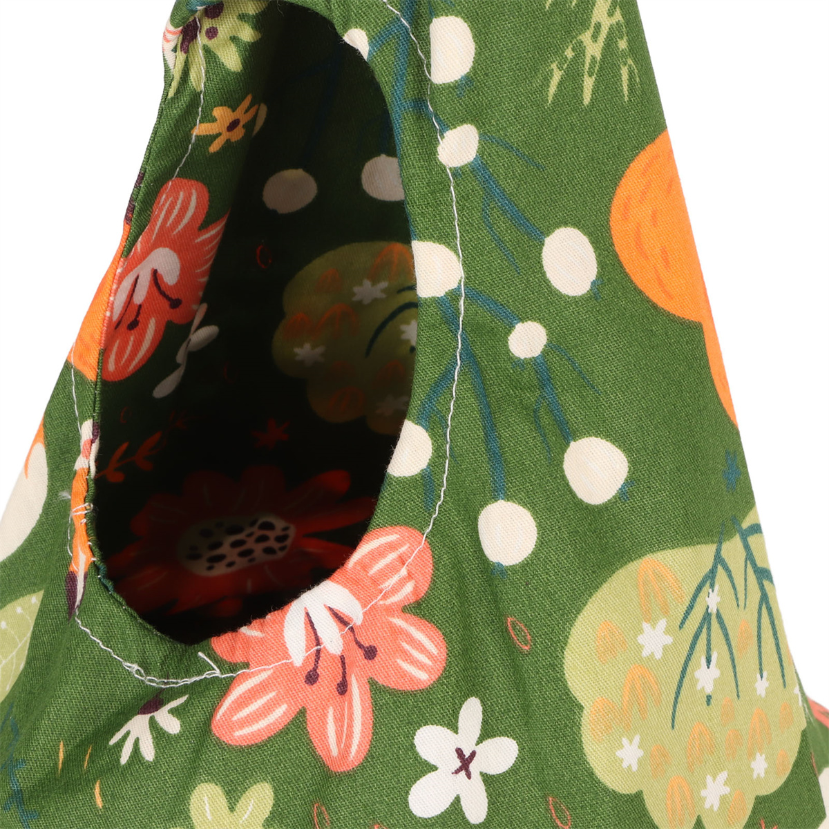 Nahaufnahme eines grünen Stoffes mit floralen Mustern und einem Loch.