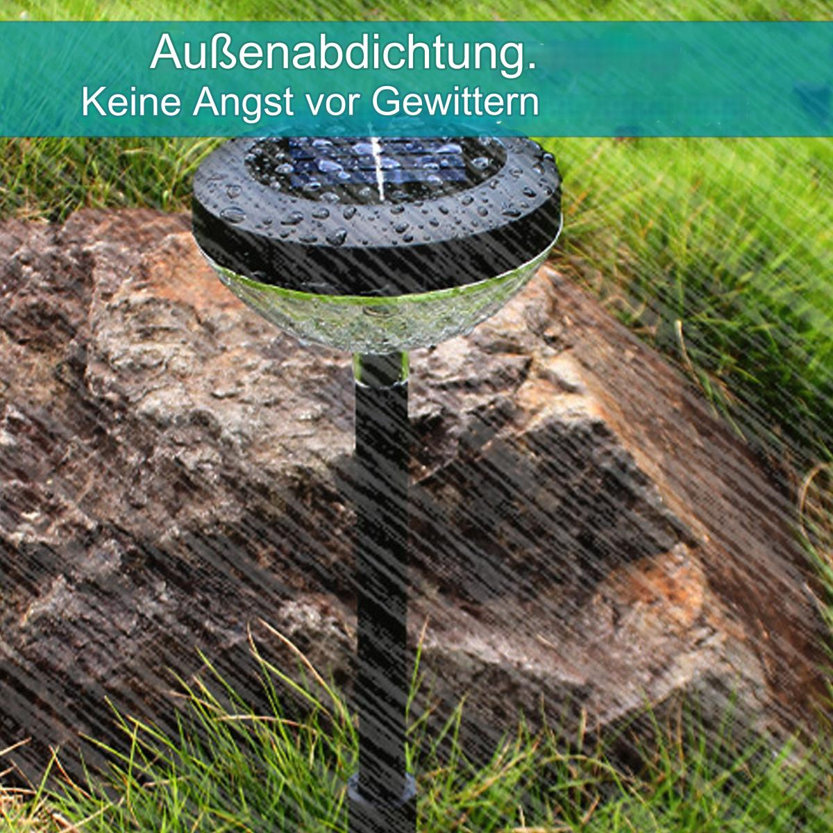 Ein Solar-Gartenlicht mit schwarzem Sockel und transparentem Deckel. Es regnet.