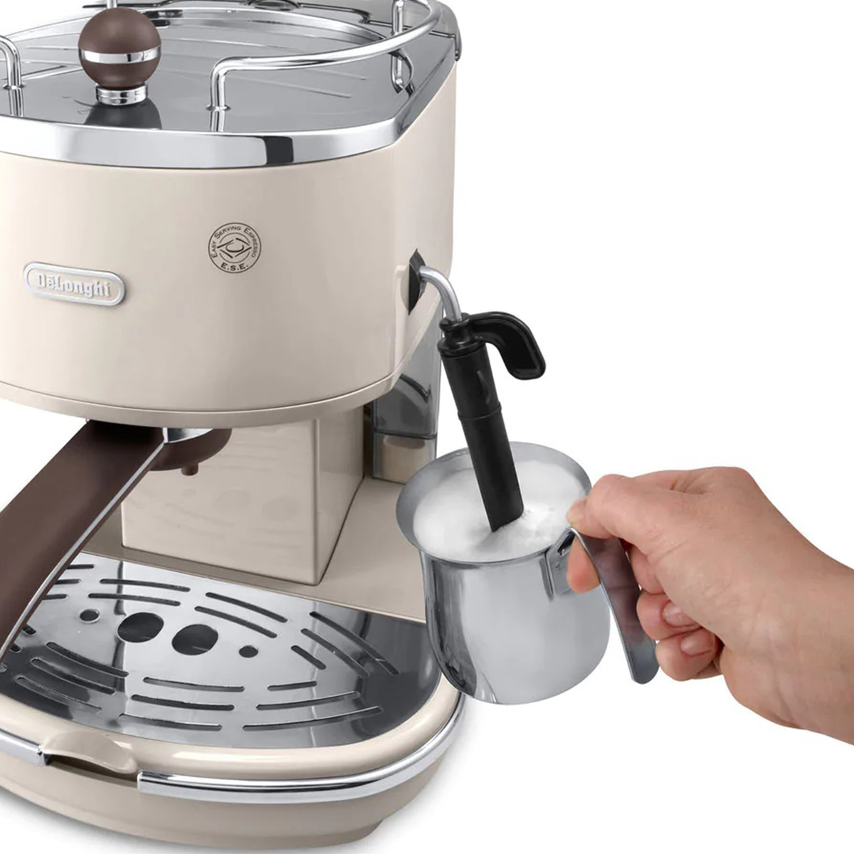 Kremowy ekspres do kawy z ręką trzymającą dzbanek do spieniania mleka.
