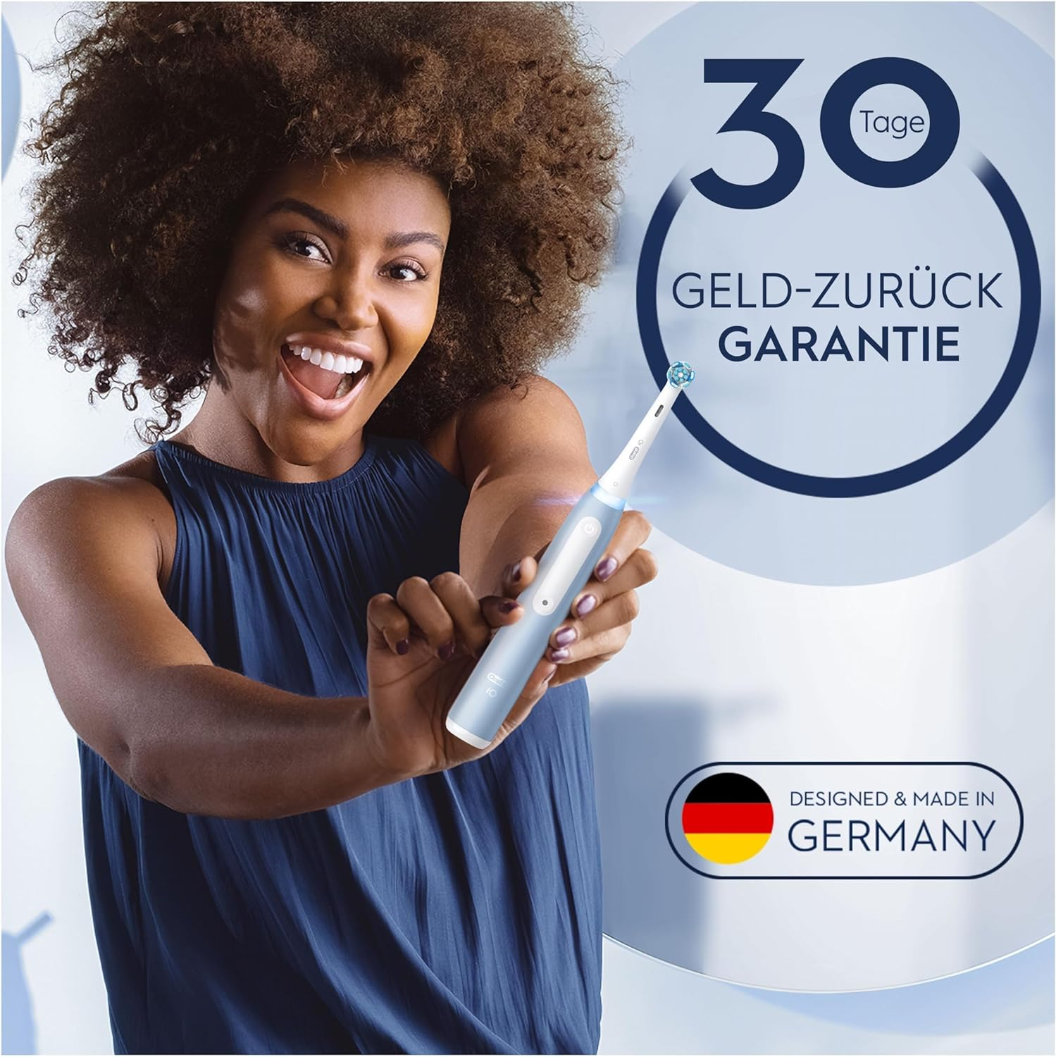 Frau hält elektrische Zahnbürste, lächelt. Text: 30 Tage Geld-Zurück Garantie. Designed & Made in Germany.