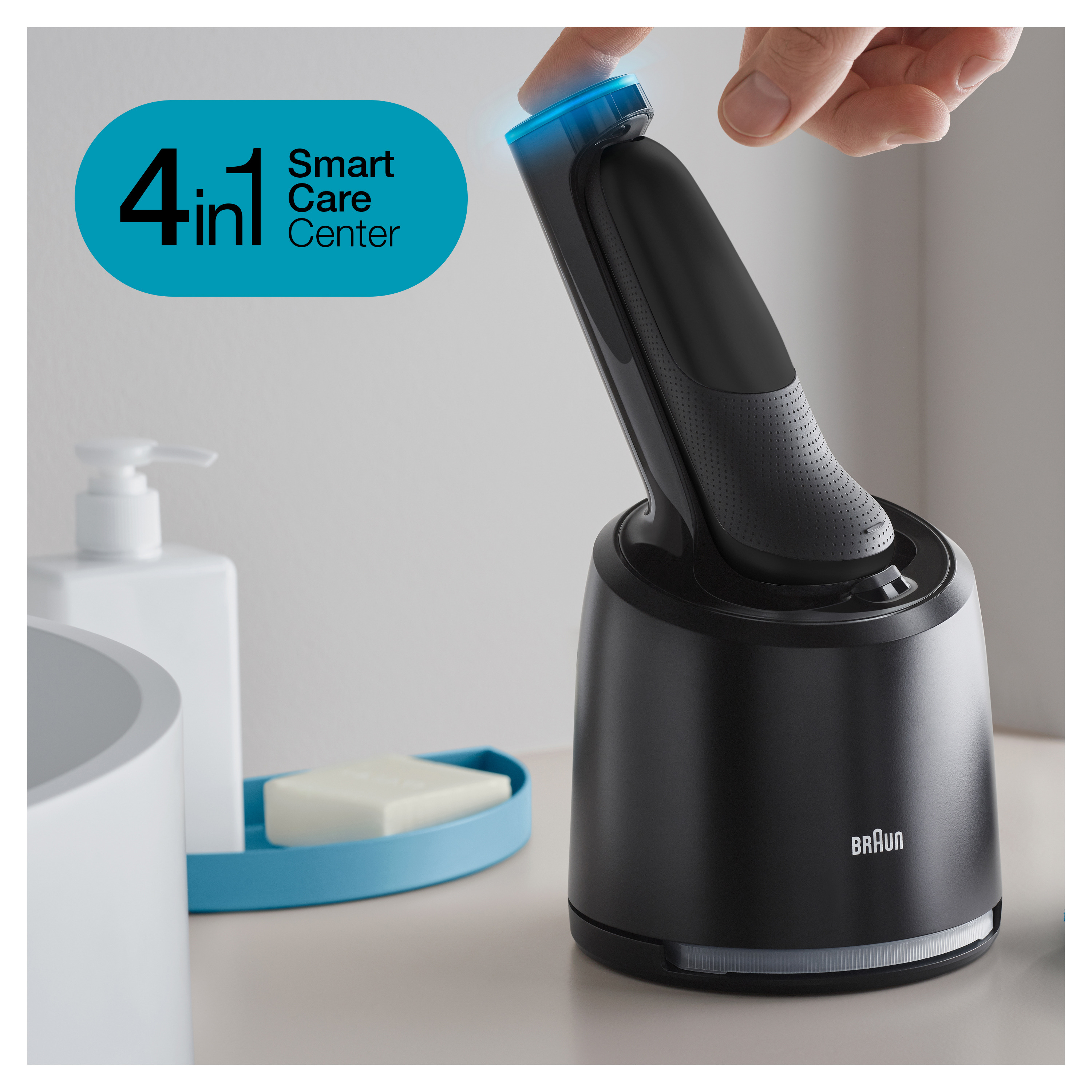 Rasoio elettrico Braun nero nella sua base di ricarica, con sapone e una bottiglia.