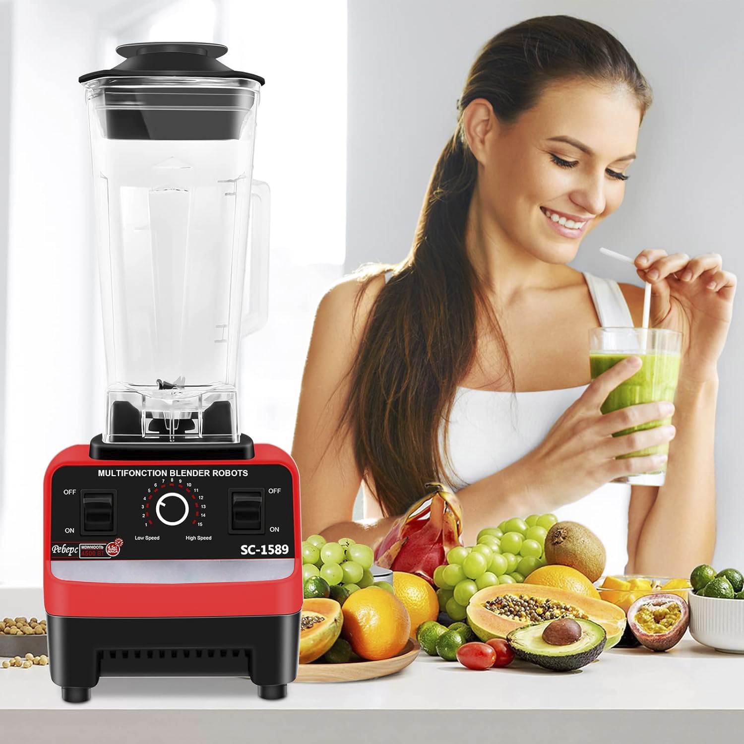 Mixer mit roter Basis, klarer Kanne. Frau trinkt grünen Smoothie. Früchte auf dem Tisch.