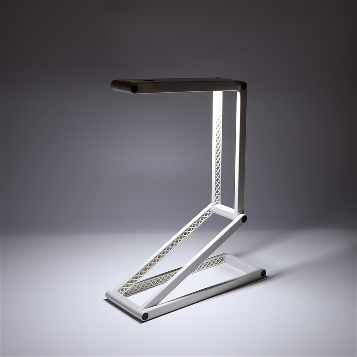 Weiße, moderne Schreibtischlampe, abgewinkeltes Design, beleuchtet.