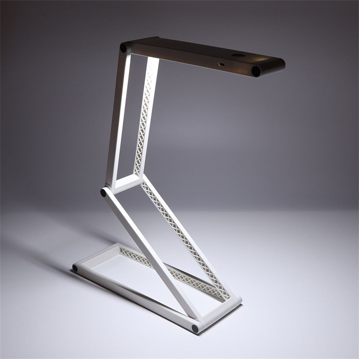 Weiße, moderne Schreibtischlampe mit rechteckigem Sockel, verstellbarem Arm und hellem Licht.