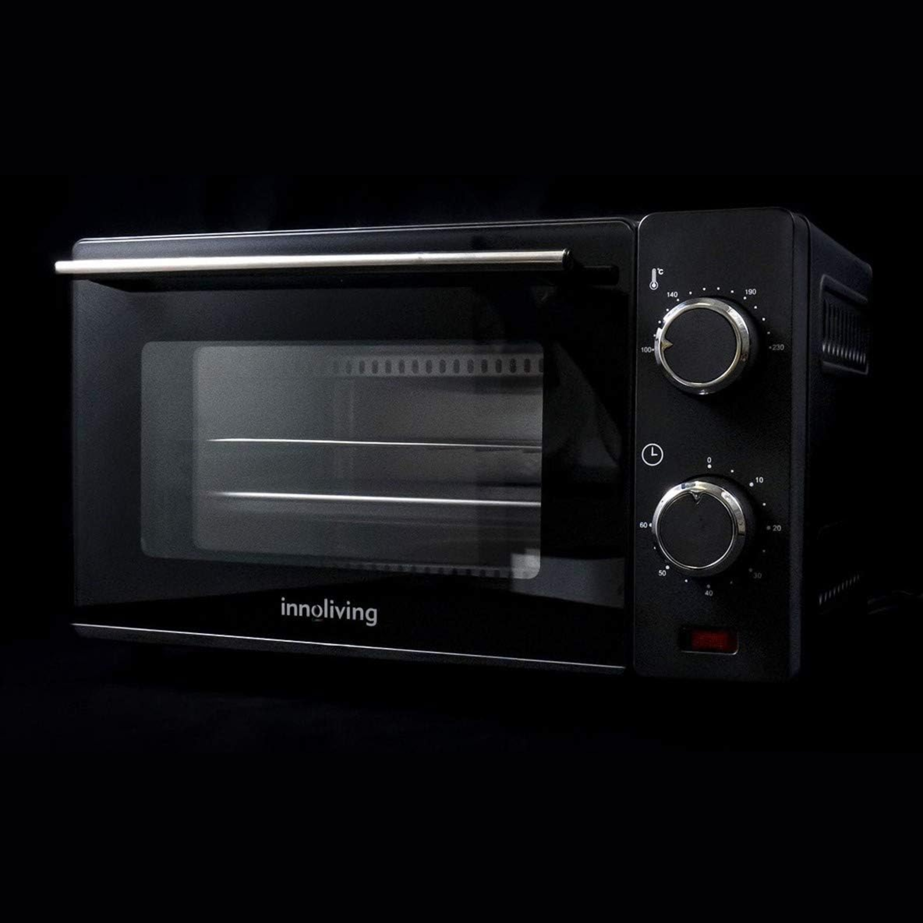Forno da banco nero. Due manopole e una maniglia. Interno visibile. Sfondo nero.