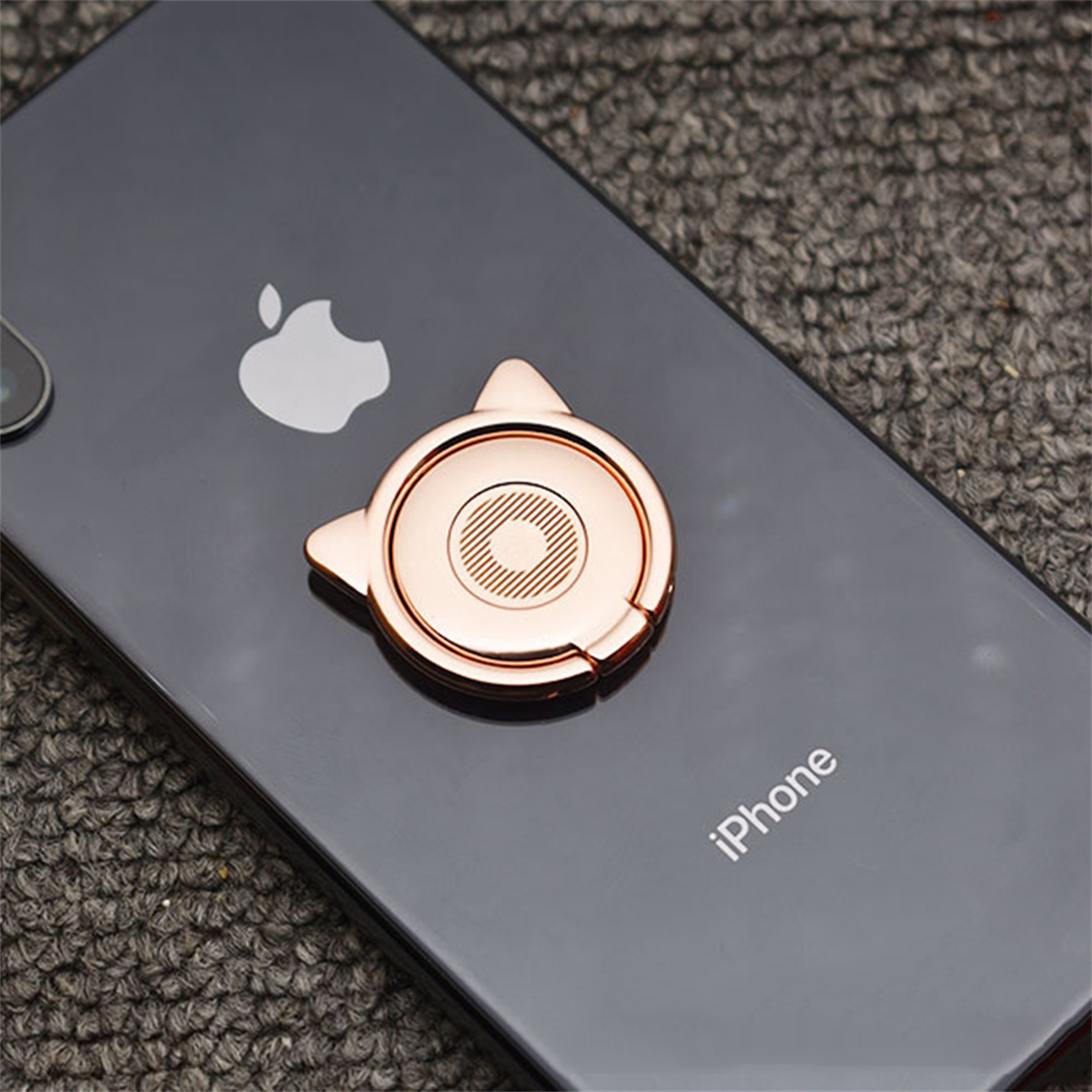 Roségoldfarbener Katzenohr-Telefonringhalter. Er ist an einem schwarzen iPhone mit dem Text 'iPhone' befestigt.