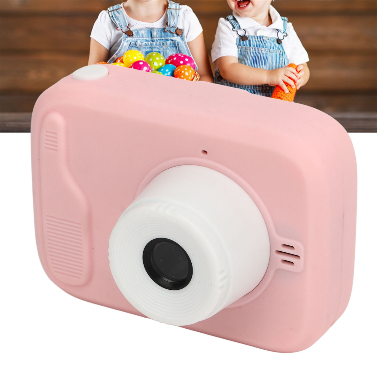 Rosa Spielzeugkamera. Zwei Kinder im Hintergrund. Eines hält die Kamera, das andere ein orangefarbenes Spielzeug. Ostereier.