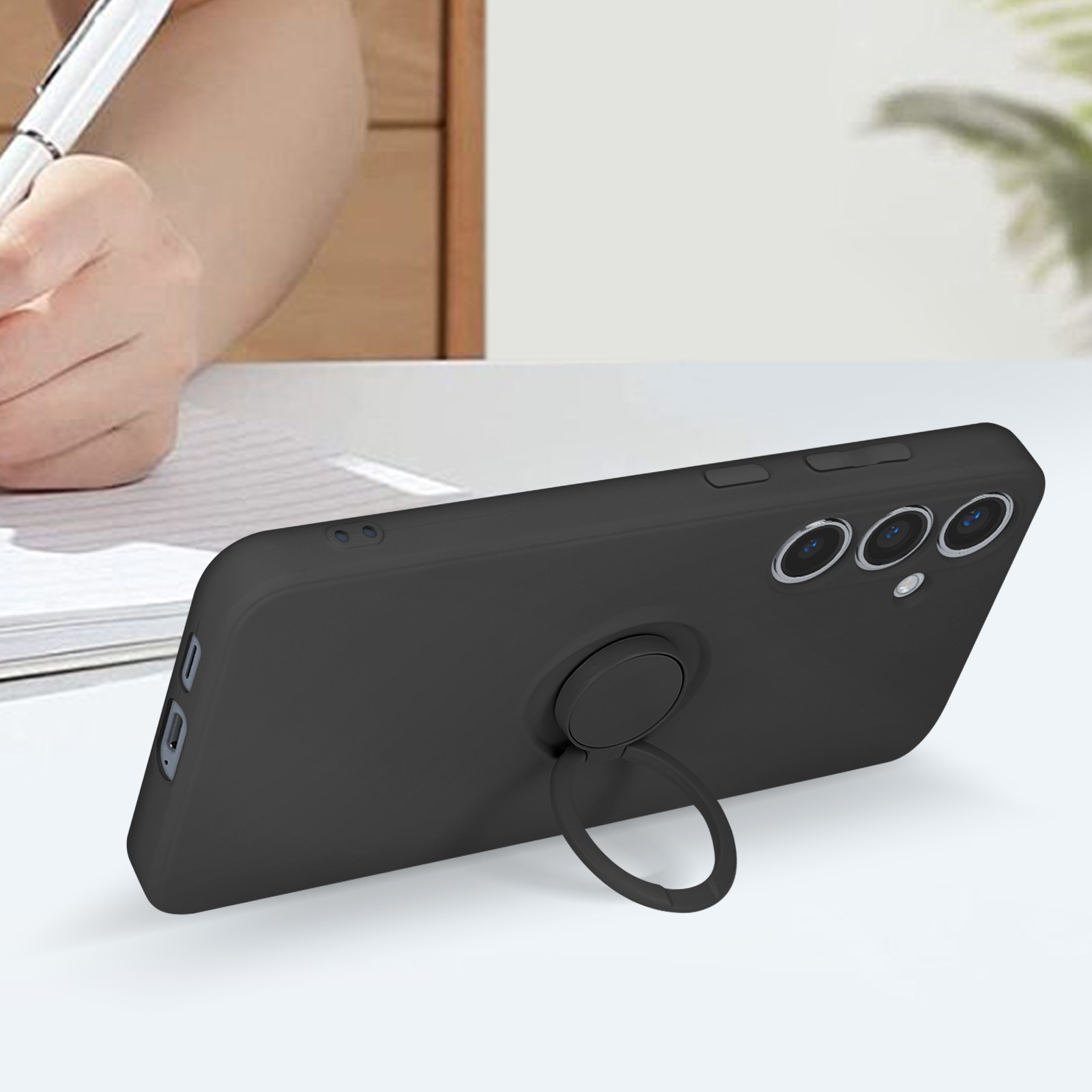 Telefono nero con supporto ad anello. È appoggiato su un tavolo e c'è una penna.