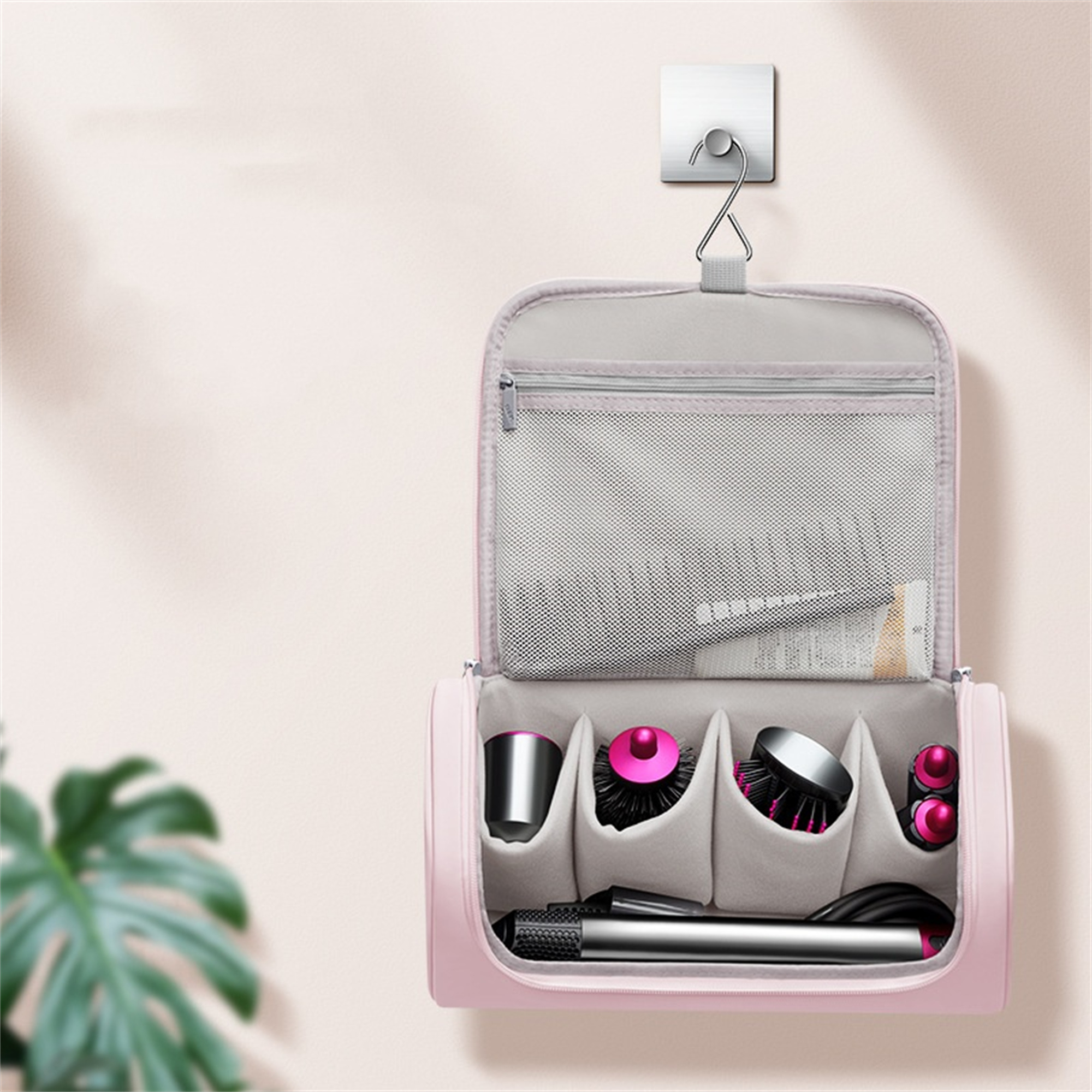Eine rosa Kosmetiktasche hängt an einem Haken. Sie enthält Zubehör, darunter Haarstylinggeräte und Bürsten.