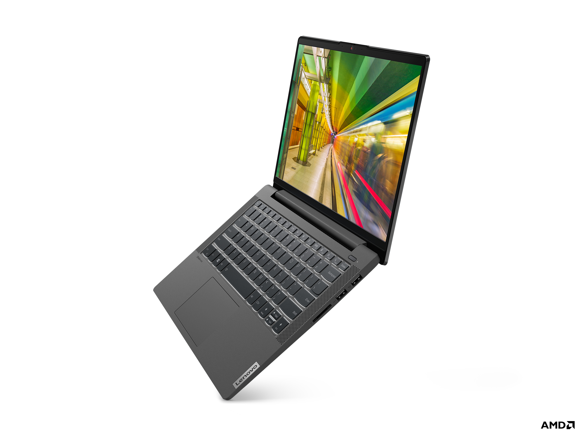 Laptop Lenovo grigio, aperto, mostra una scena colorata di treni sullo schermo, su una superficie bianca.