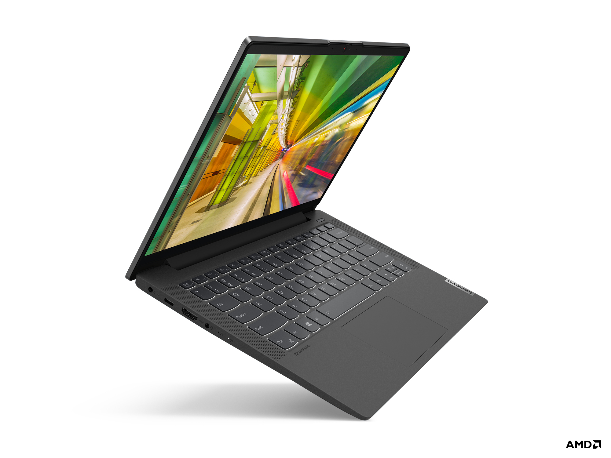 Laptop Lenovo grigio, aperto, mostra una scena colorata di treni sullo schermo, su una superficie bianca.