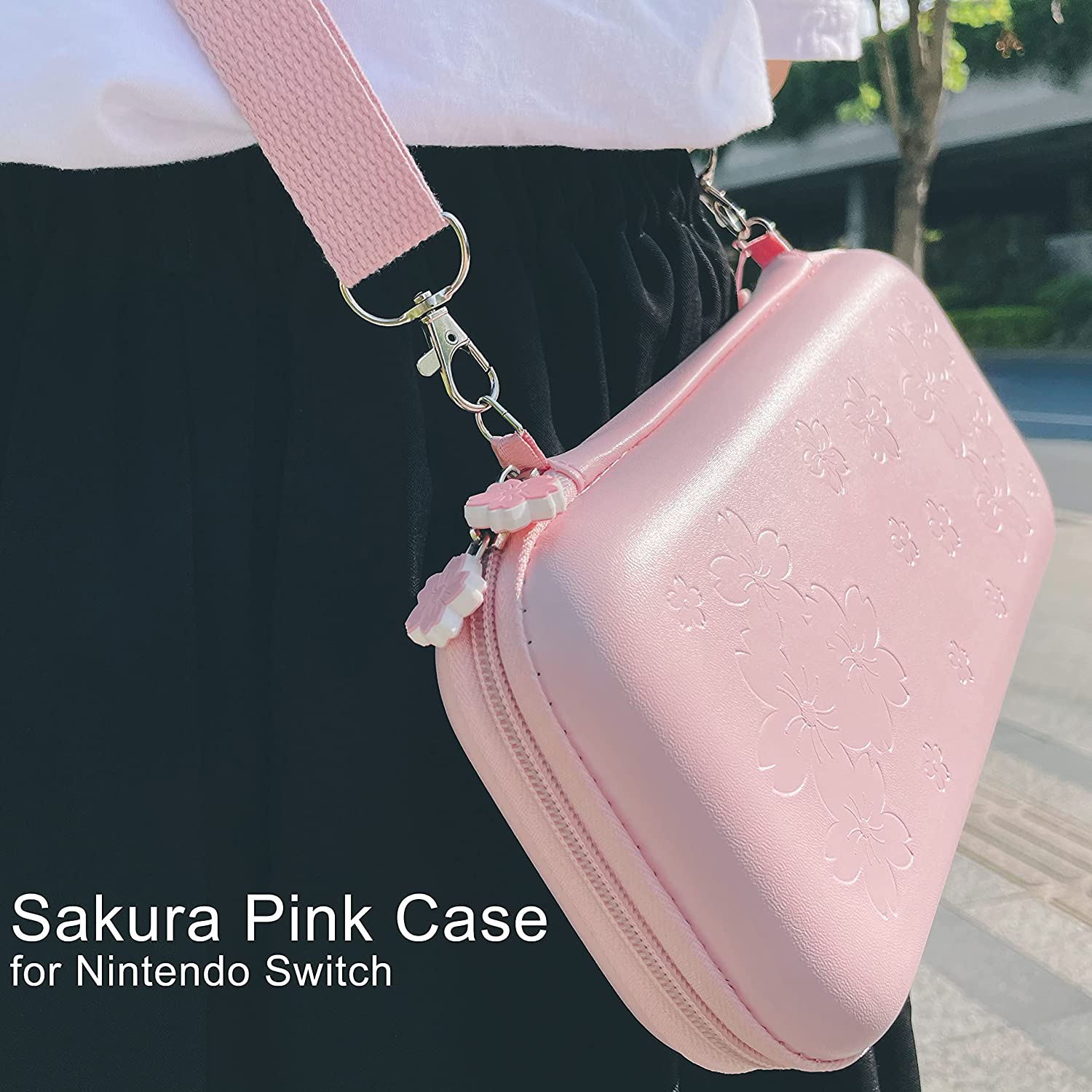 Roze Switch-hoesje met een riem, persoon op de achtergrond. De hoes heeft een bloemvormige ritssluiting.