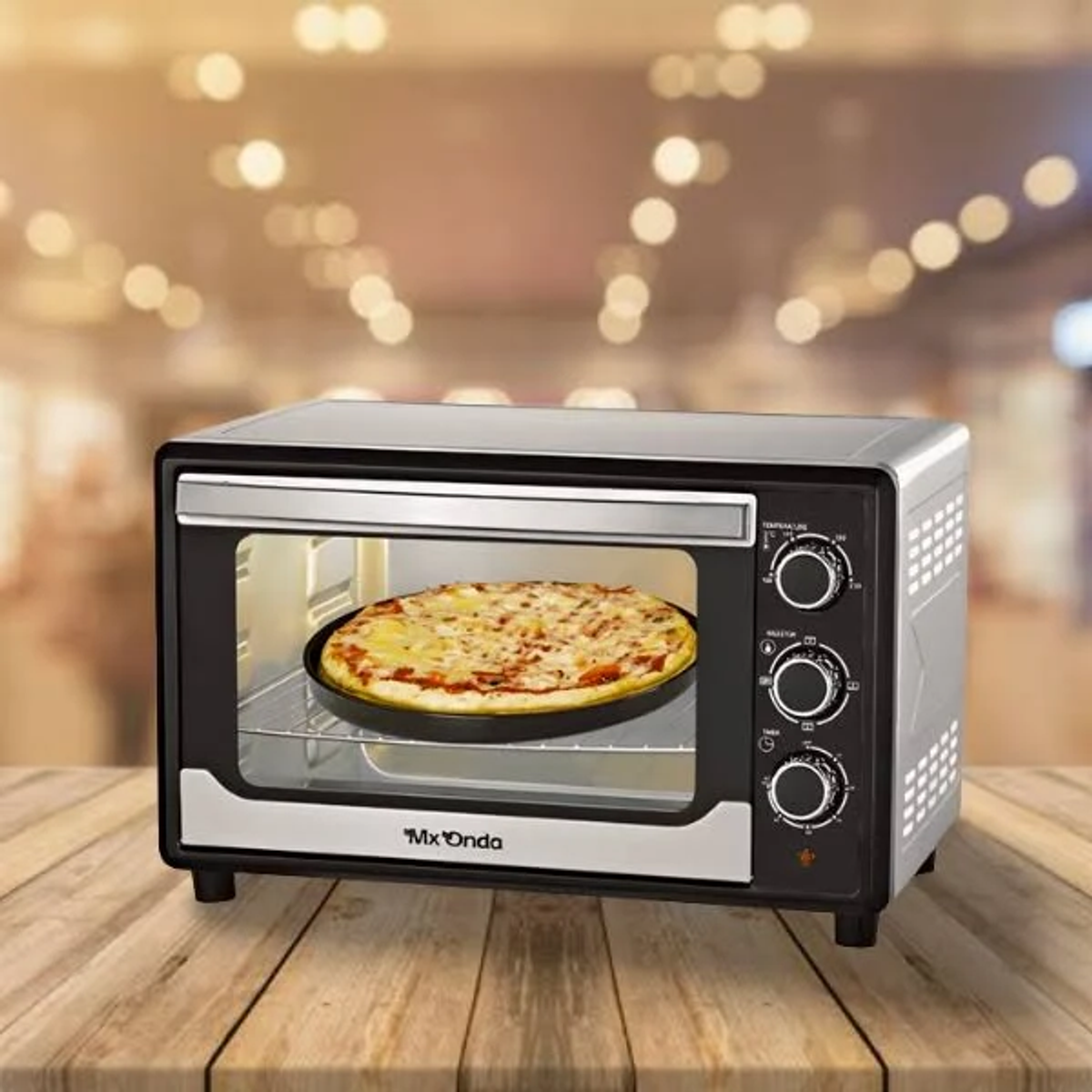 Pizza w czarnym piekarniku, szklane drzwi, elementy sterujące po prawej. Drewniany stół i rozmyte tło.