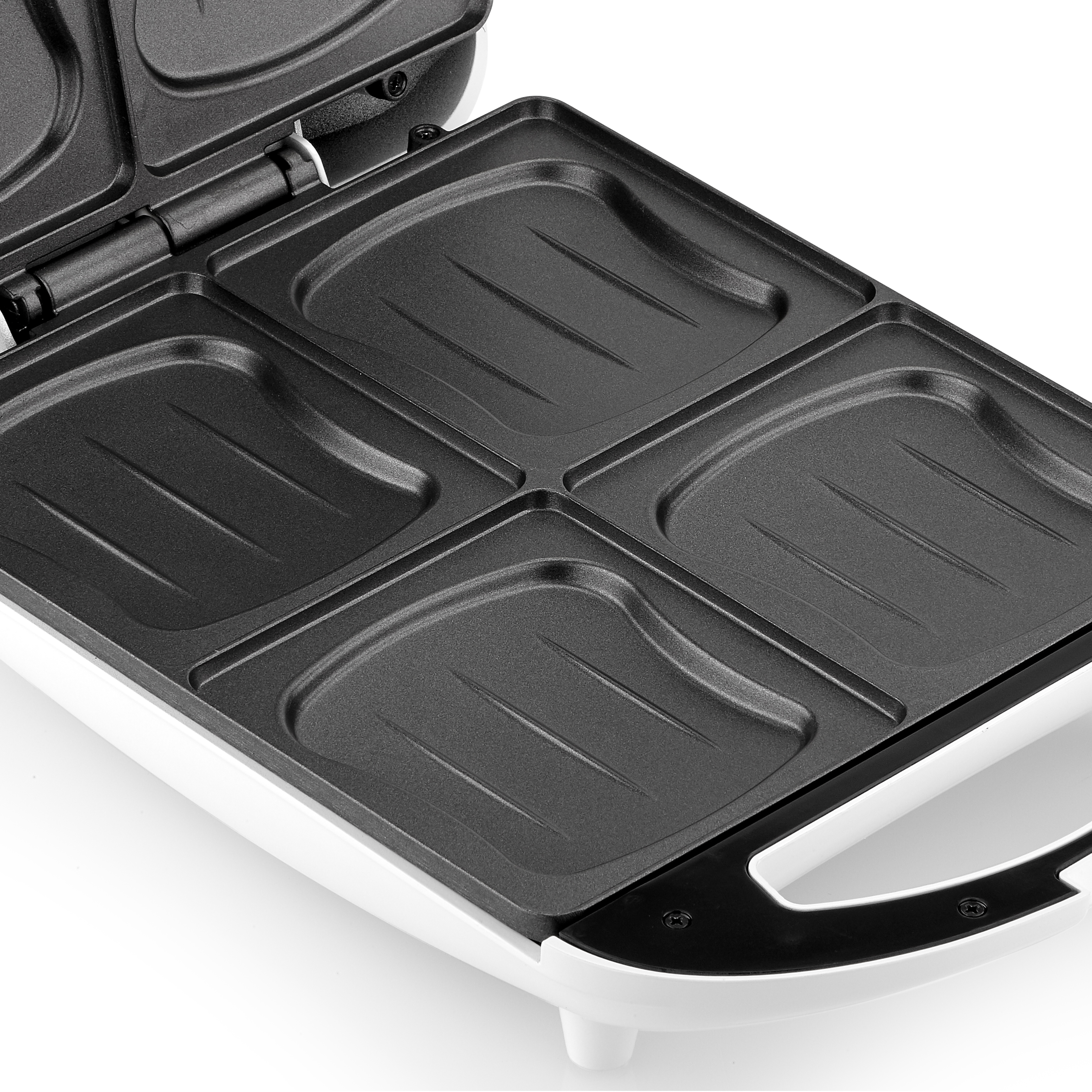 Primer plano de una sandwichera abierta, mostrando cuatro moldes vacíos.