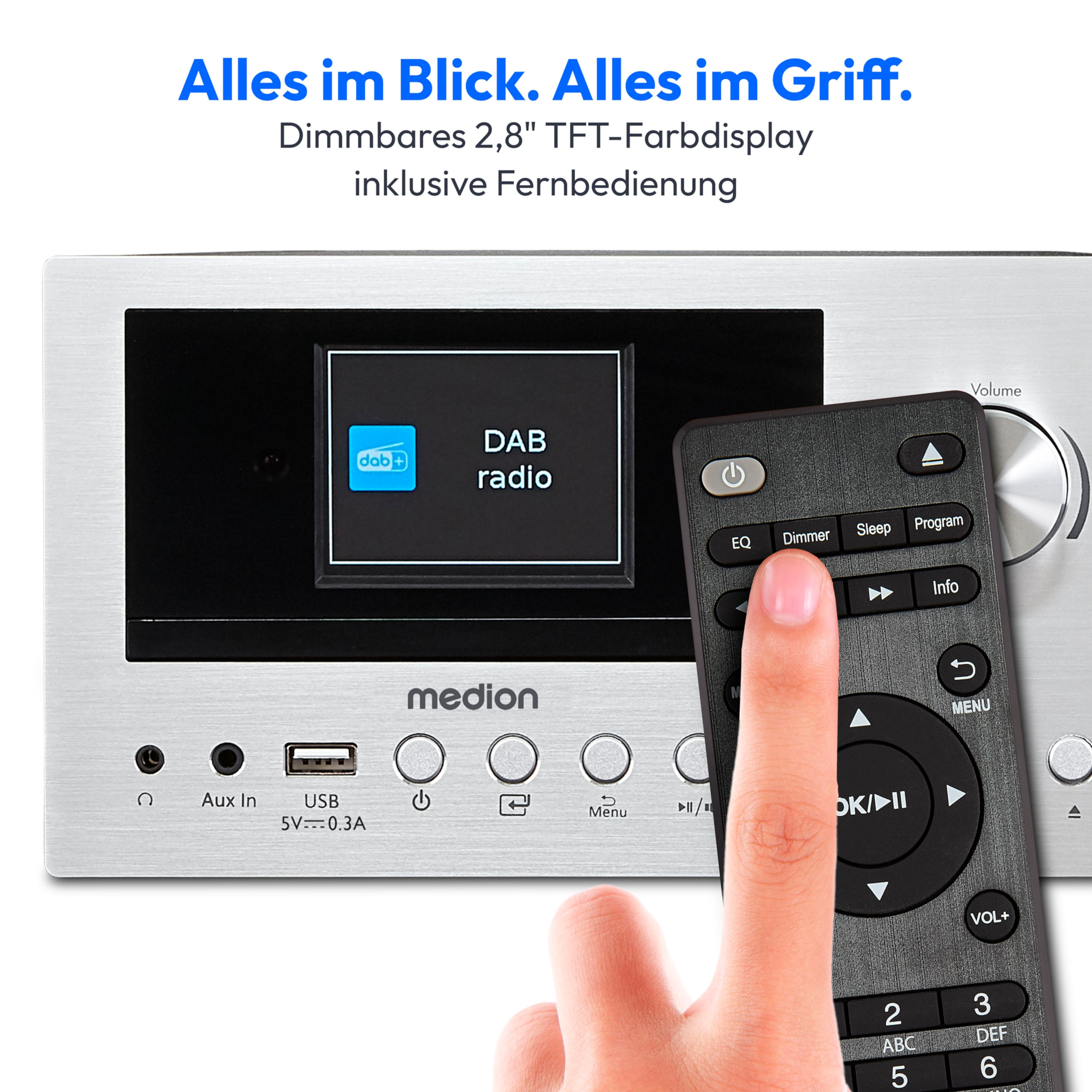 Eine Hand bedient mit einer Fernbedienung ein DAB-Radio mit Display und Knöpfen.