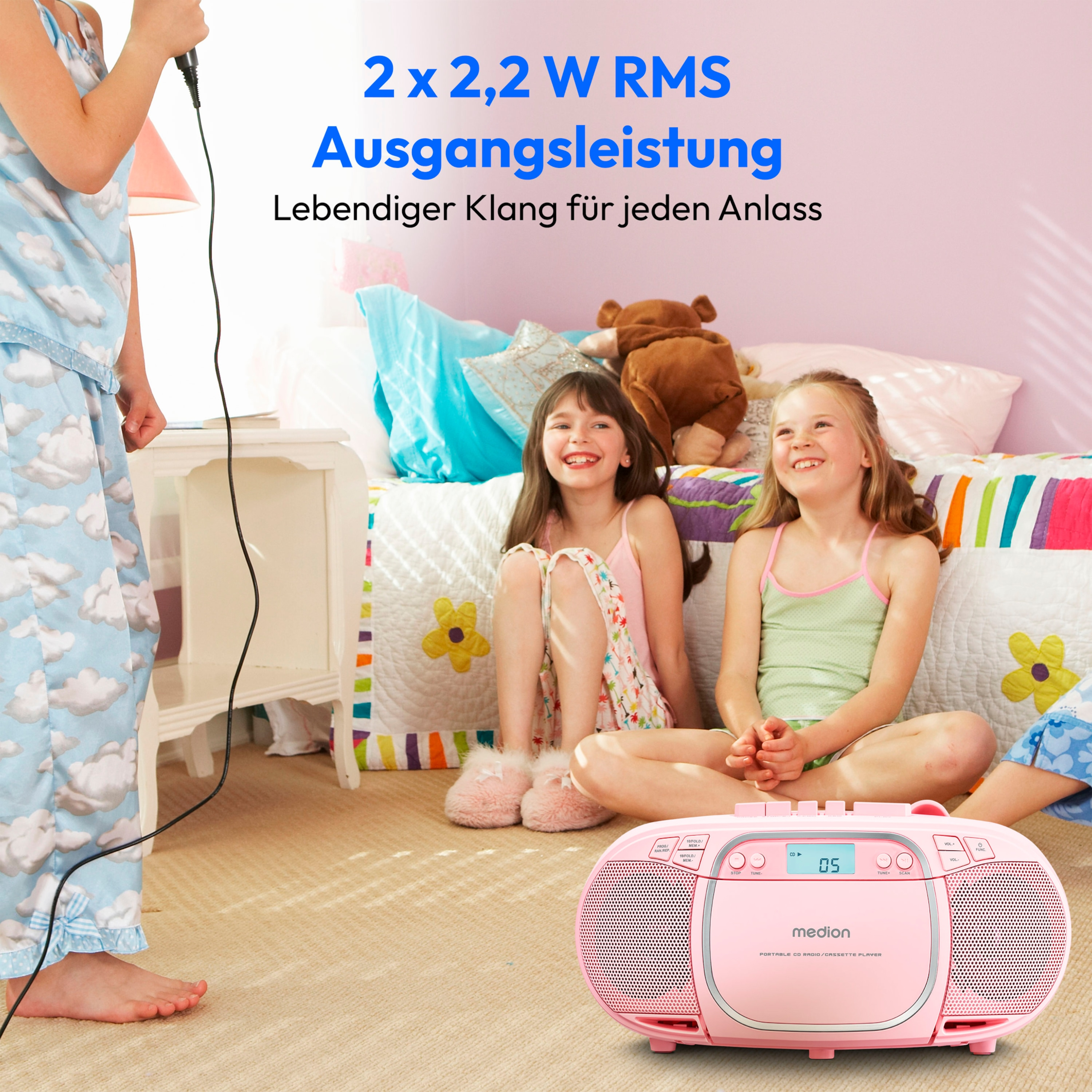 Zwei Mädchen singen in ein Mikrofon. Rosa Boombox auf dem Boden. Schlafzimmer.