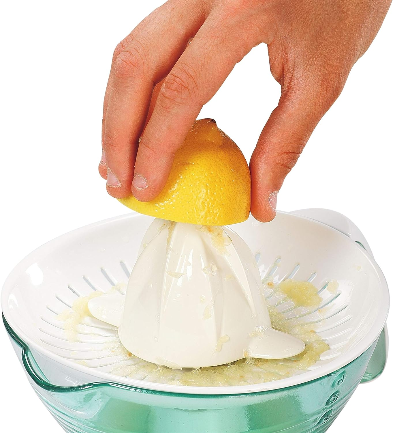 Osoba wyciska połówkę cytryny do białej wyciskarki, nad zieloną miską.