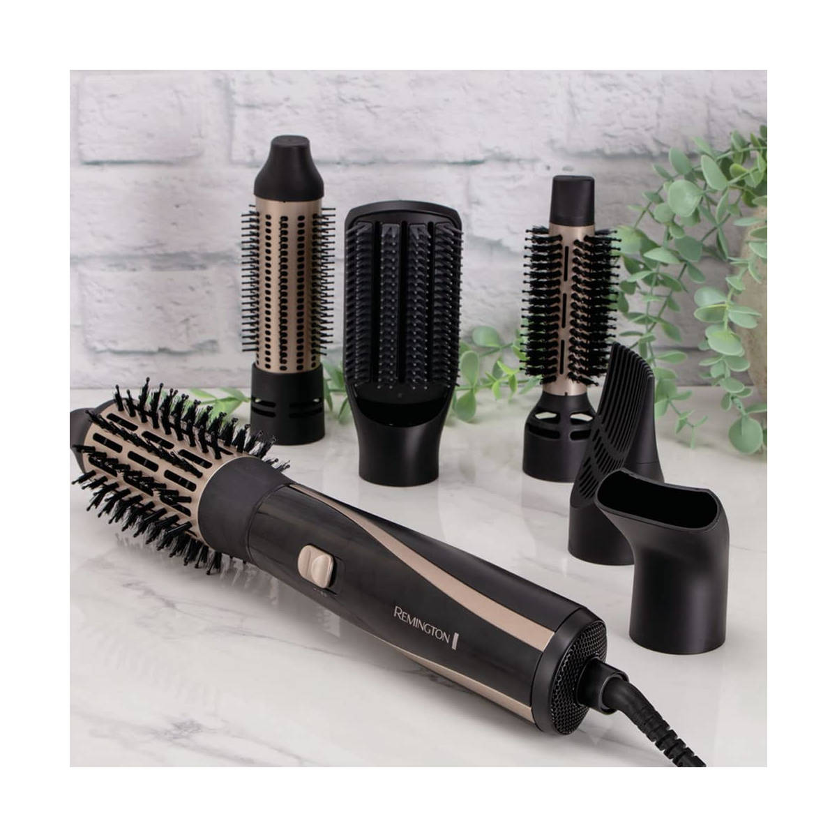 Haarstyling-Set. Enthält eine rotierende Bürste, mehrere Aufsätze und eine Basis. Weißer Hintergrund.