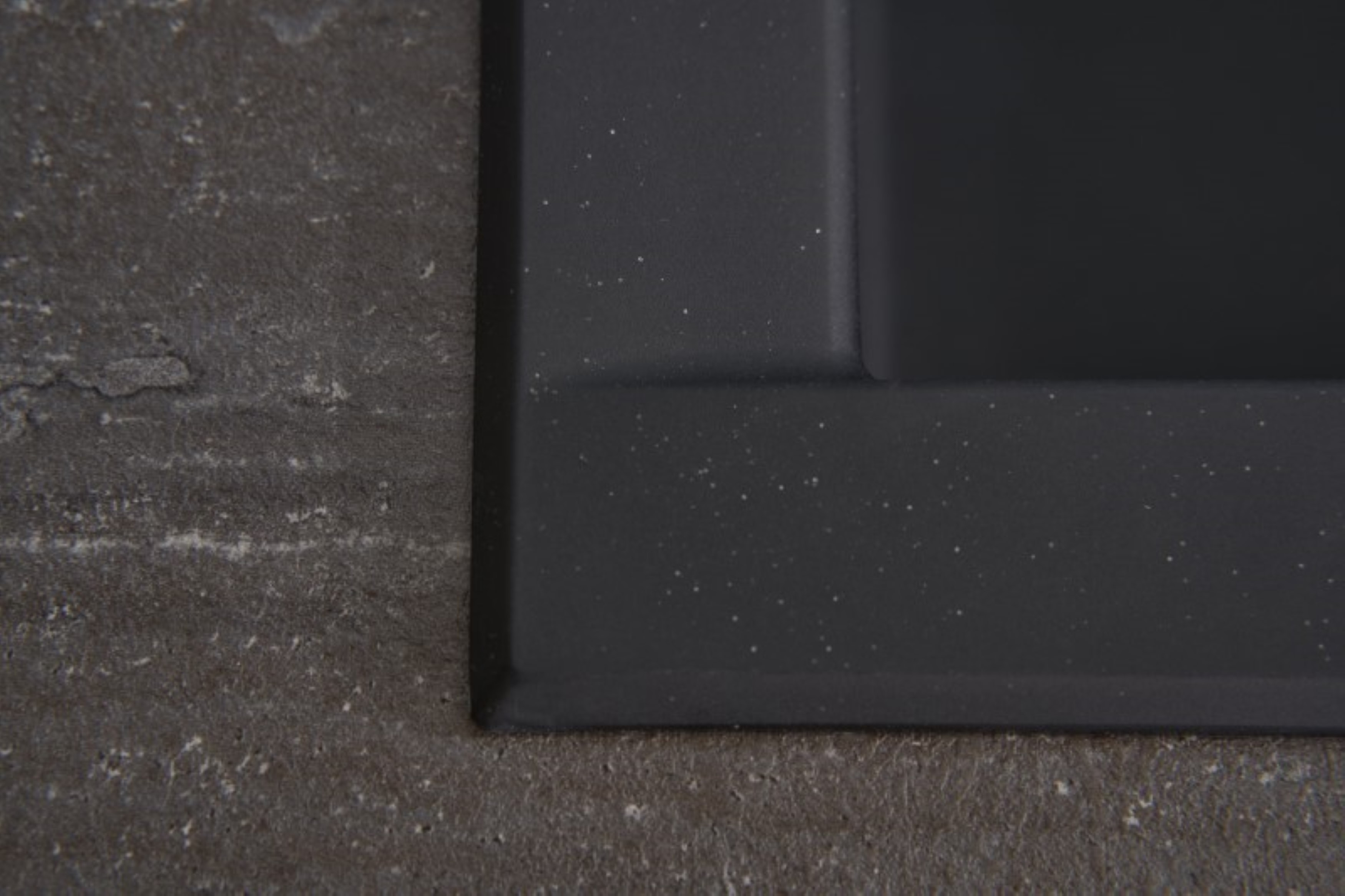 Primo piano di una superficie di pietra grigio scuro strutturata.