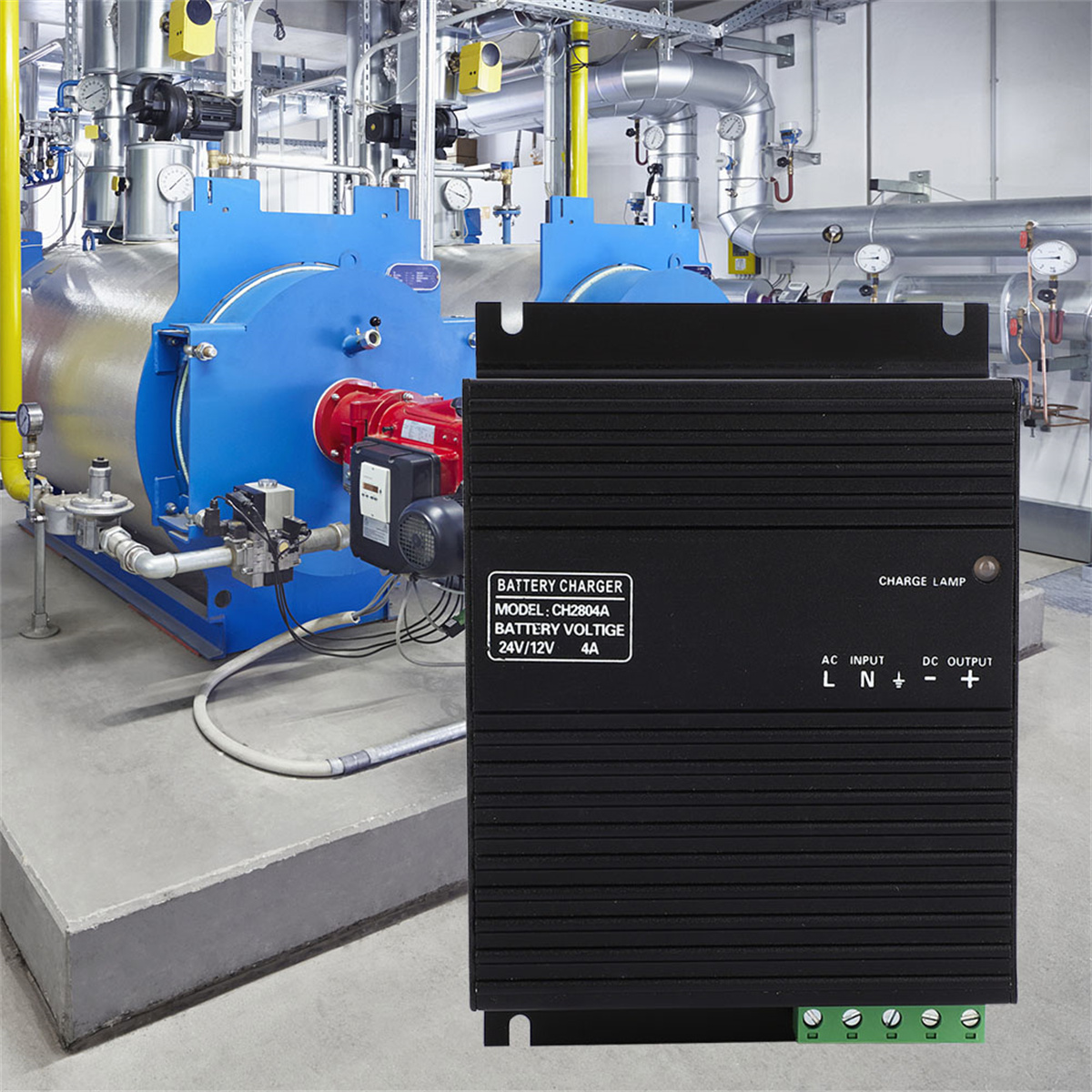 Ein schwarzes Batterieladegerät mit Etiketten in einer Industrieumgebung, in der Nähe von Maschinen.