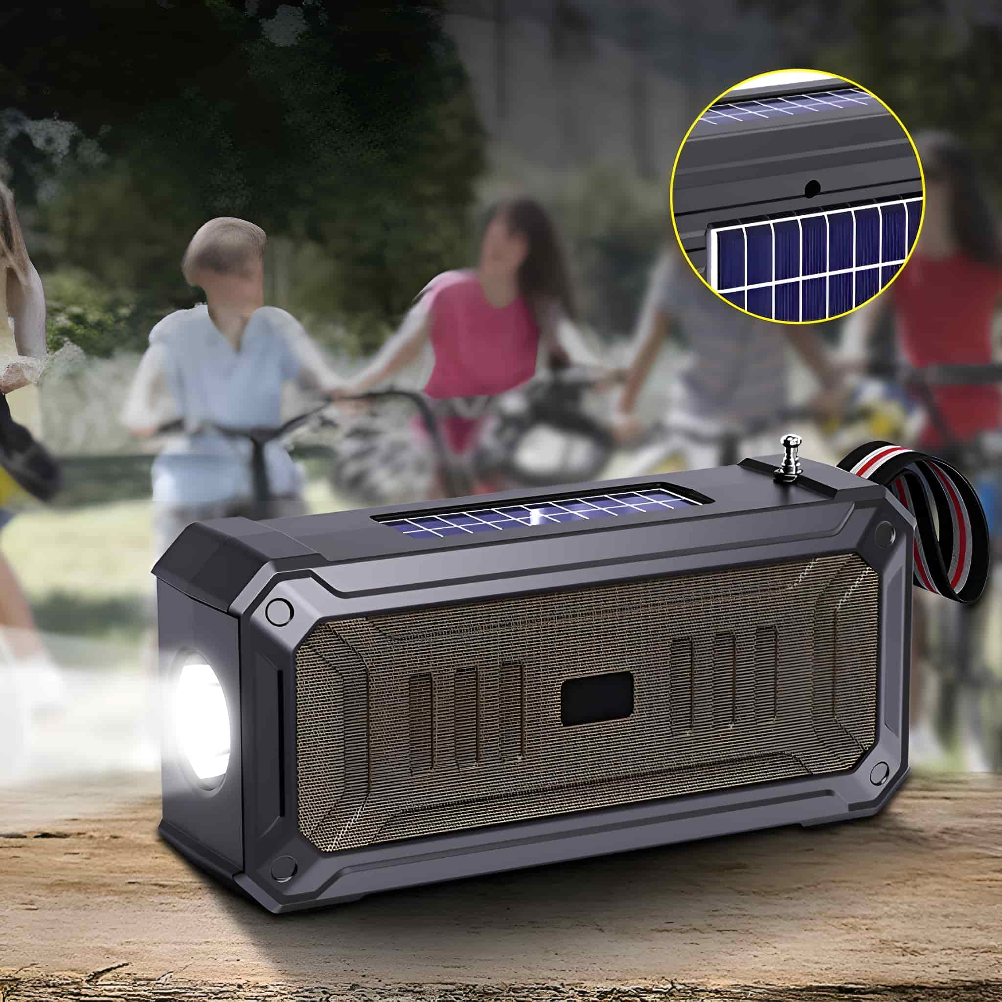 Schwarzer Lautsprecher mit Solarpanel, Licht und Griff. Menschen auf Fahrrädern unscharf im Hintergrund.