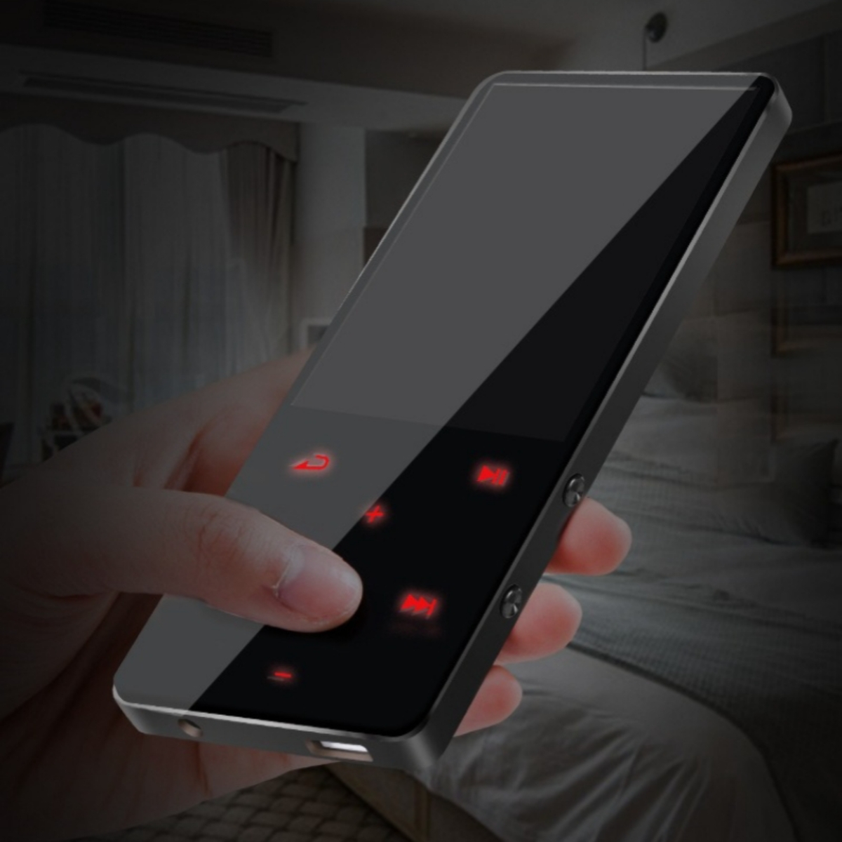 Hand hält ein glänzendes, schwarzes Smartphone mit roten Knöpfen in einem Schlafzimmer.