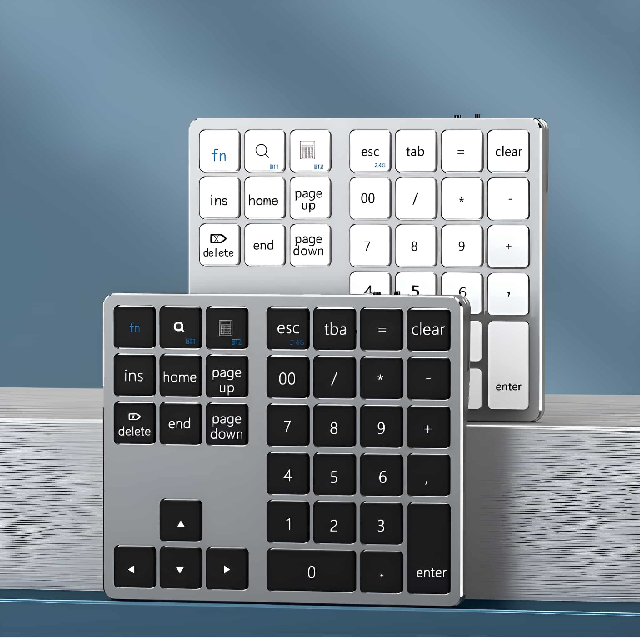 Zwei silberne Nummern-Keypads auf einer weißen Oberfläche. Eines im Vordergrund, eines leicht dahinter.