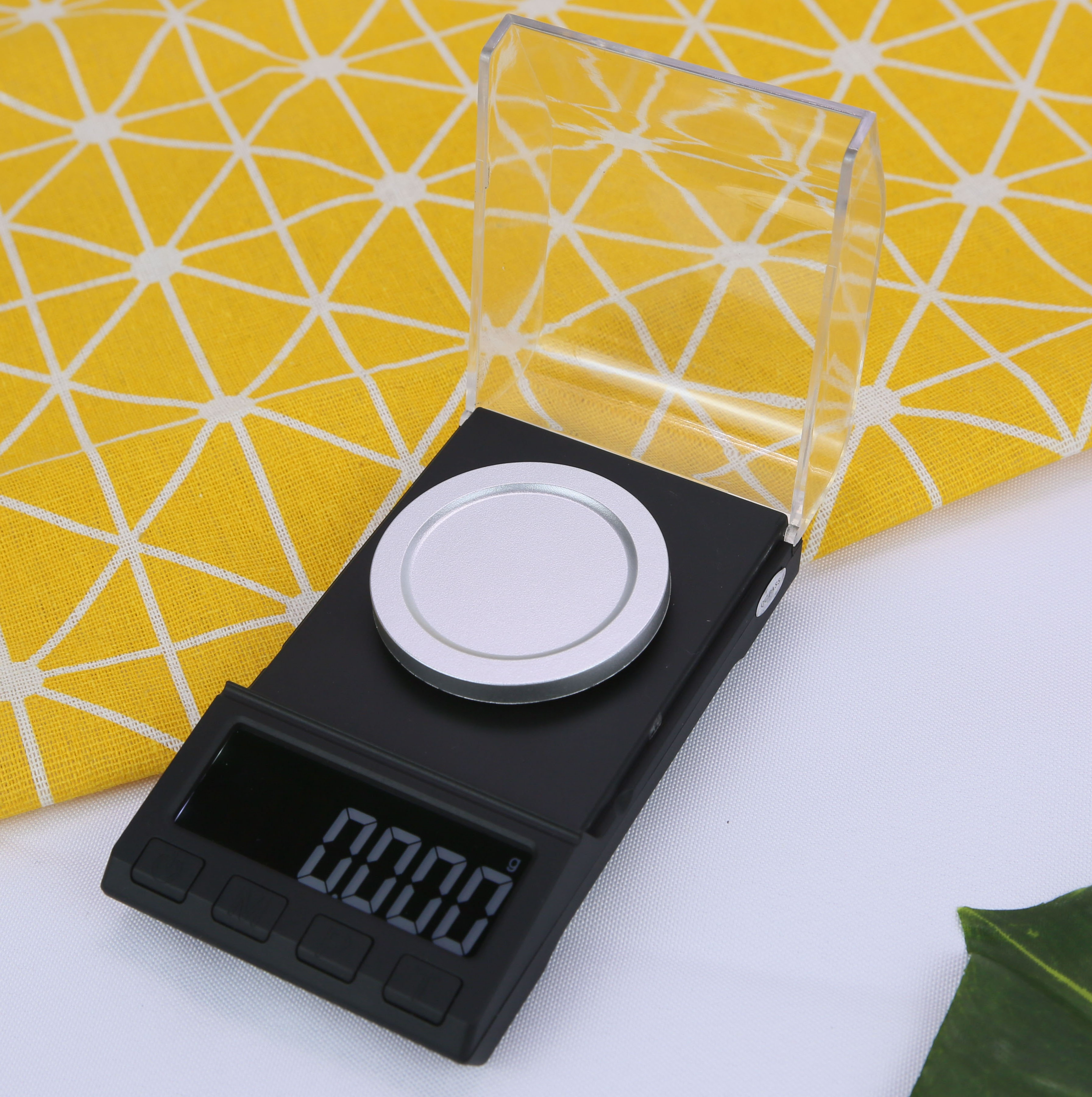 Czarna waga cyfrowa ze srebrną okrągłą płytką. Wyświetlacz pokazuje 0,000.