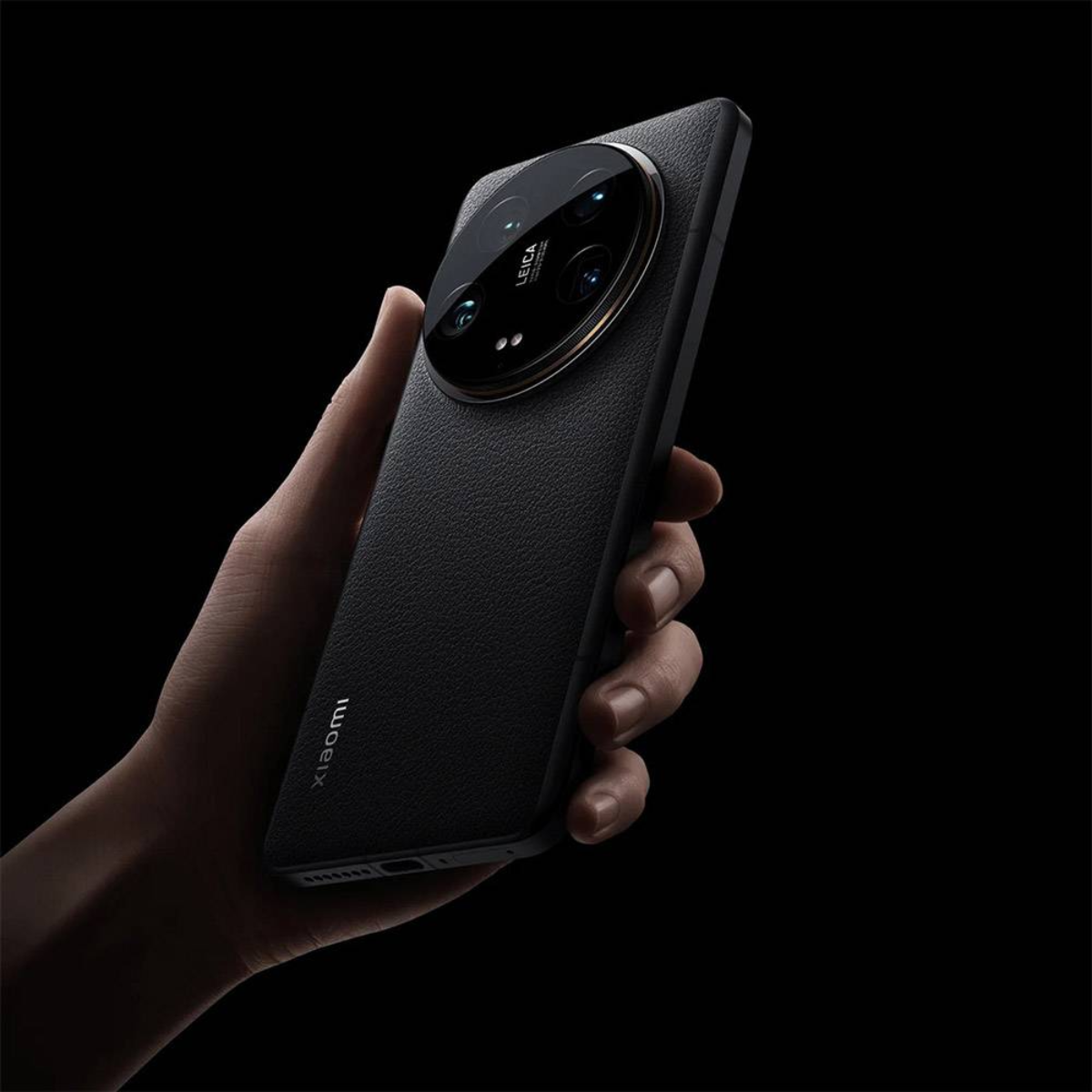 Dłoń trzymająca czarny telefon. Telefon ma duży aparat z marką Leica.