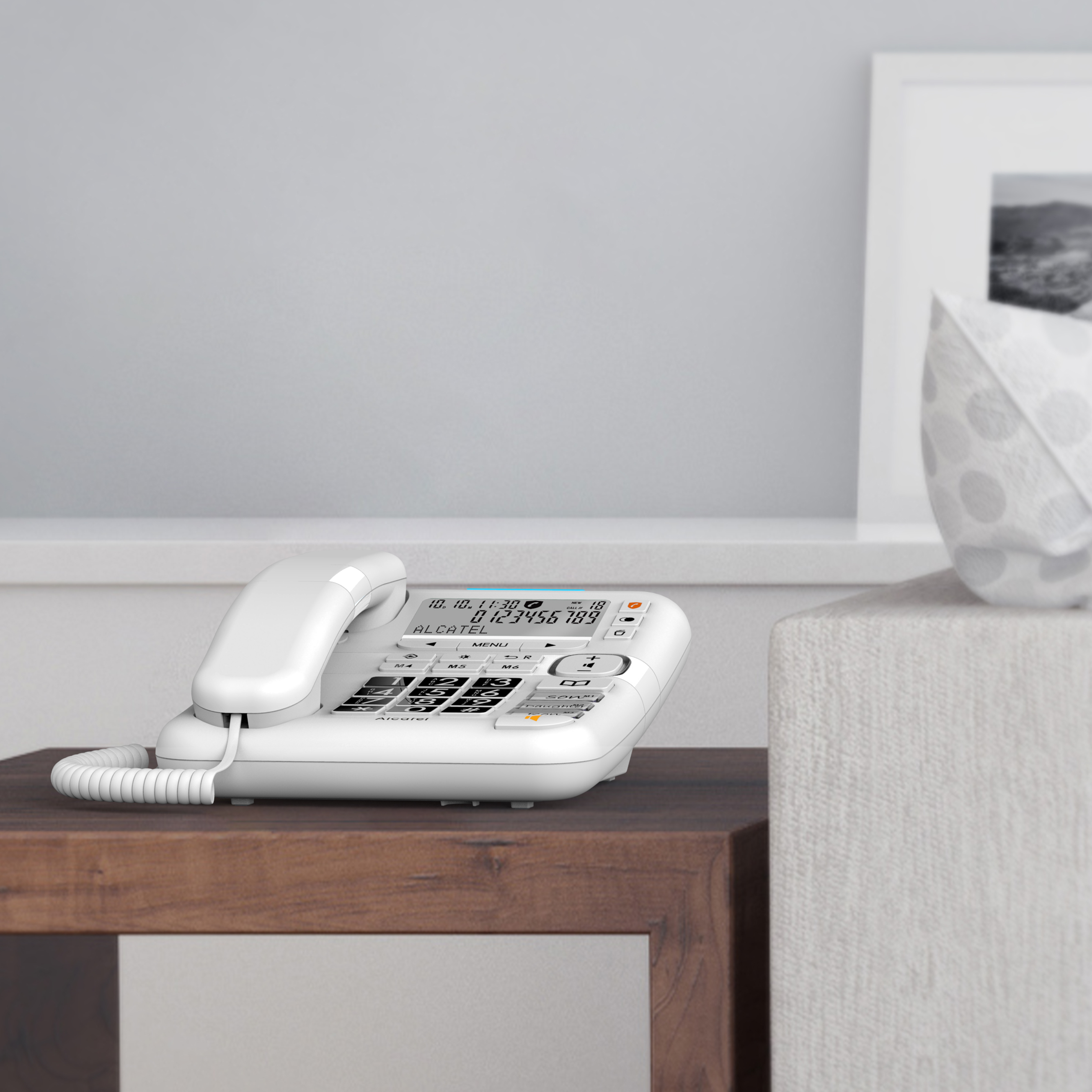 Witte Alcatel telefoon op een houten tafel. De telefoon toont de tijd en een telefoonnummer.