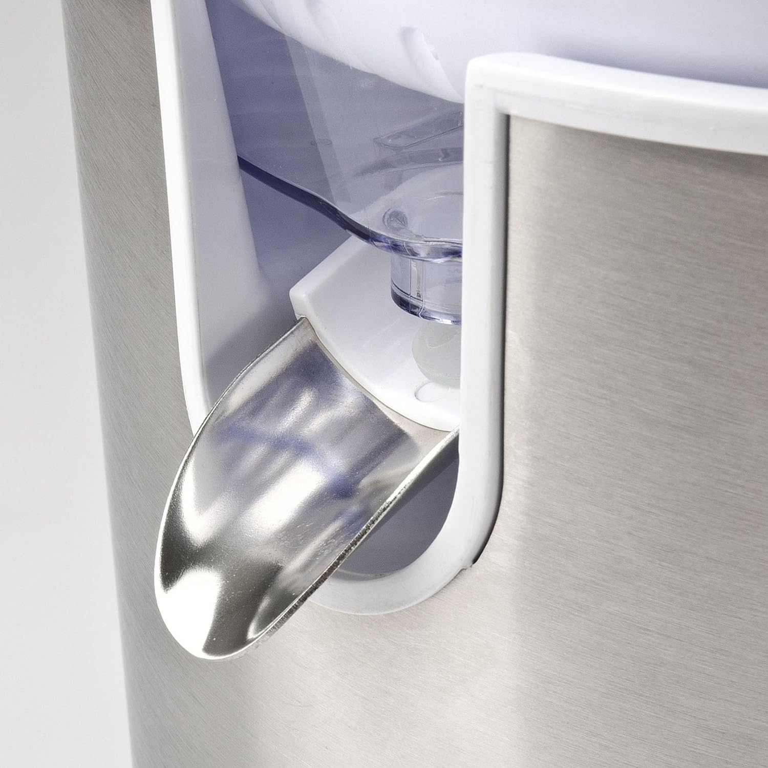 Zbliżenie srebrnego wylotu soku z wyciskarki na białym tle.